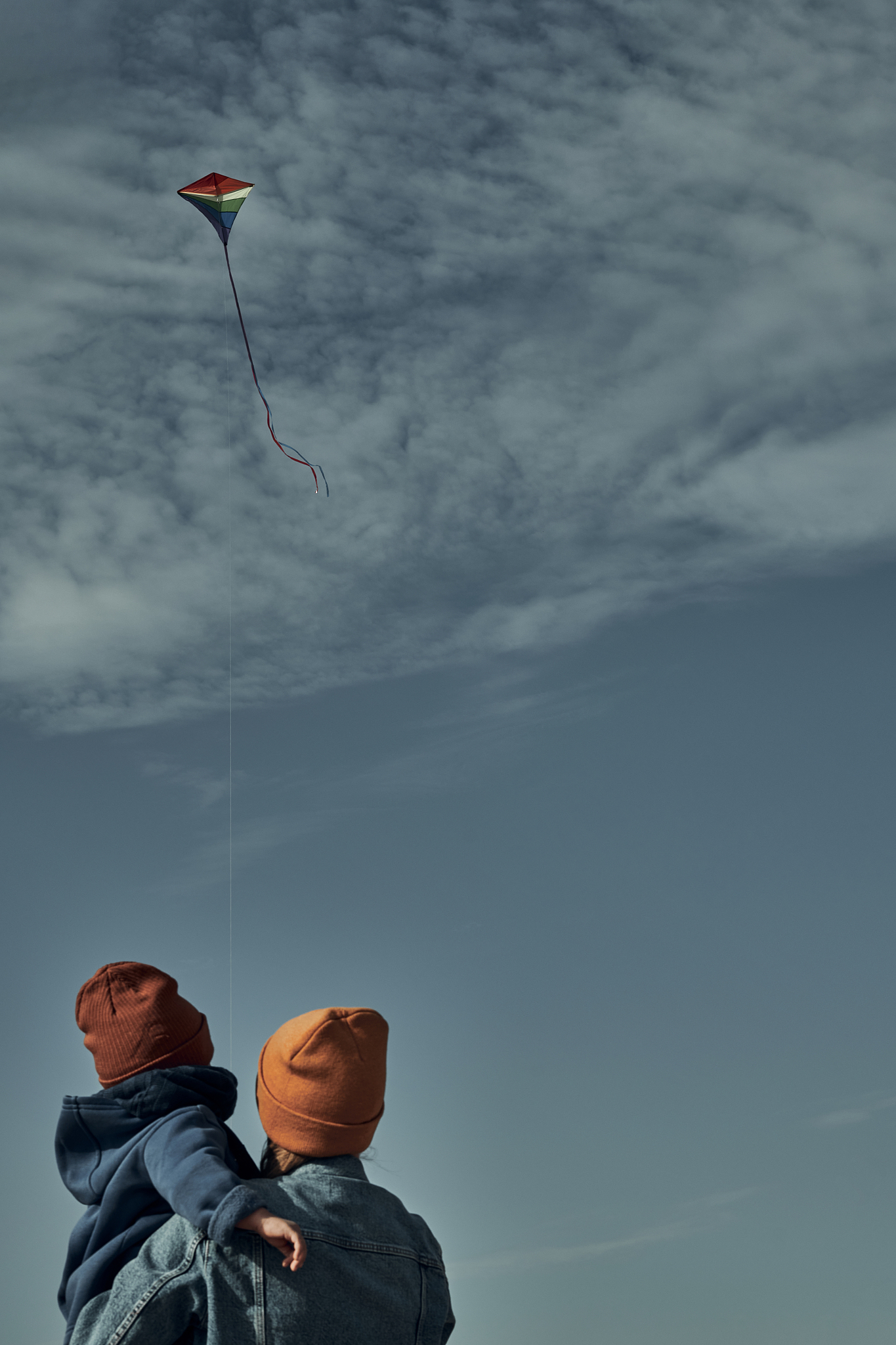 a woman with a two-year-old child is flying a kite. games with c