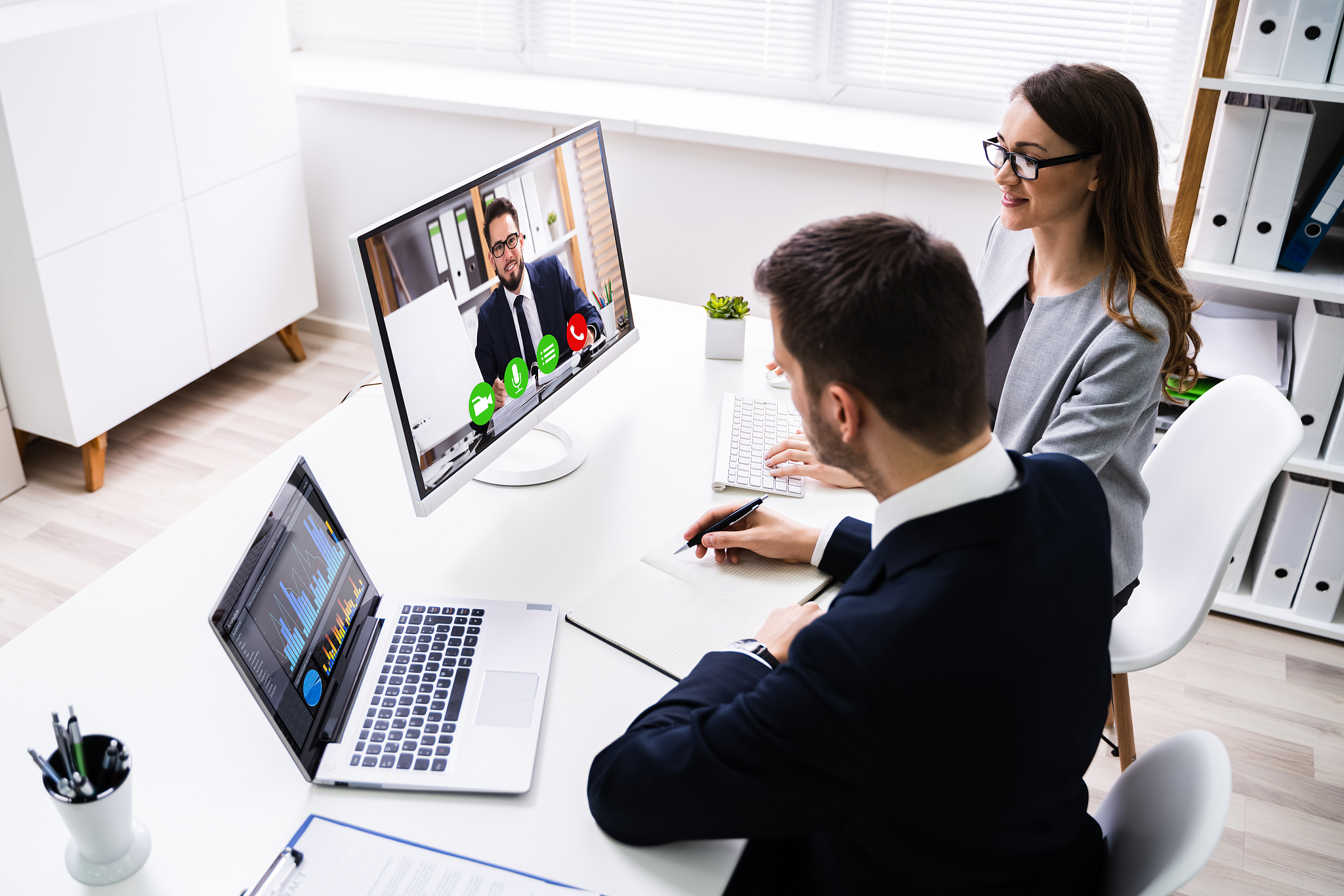 two businesspeople video conferencing on computer