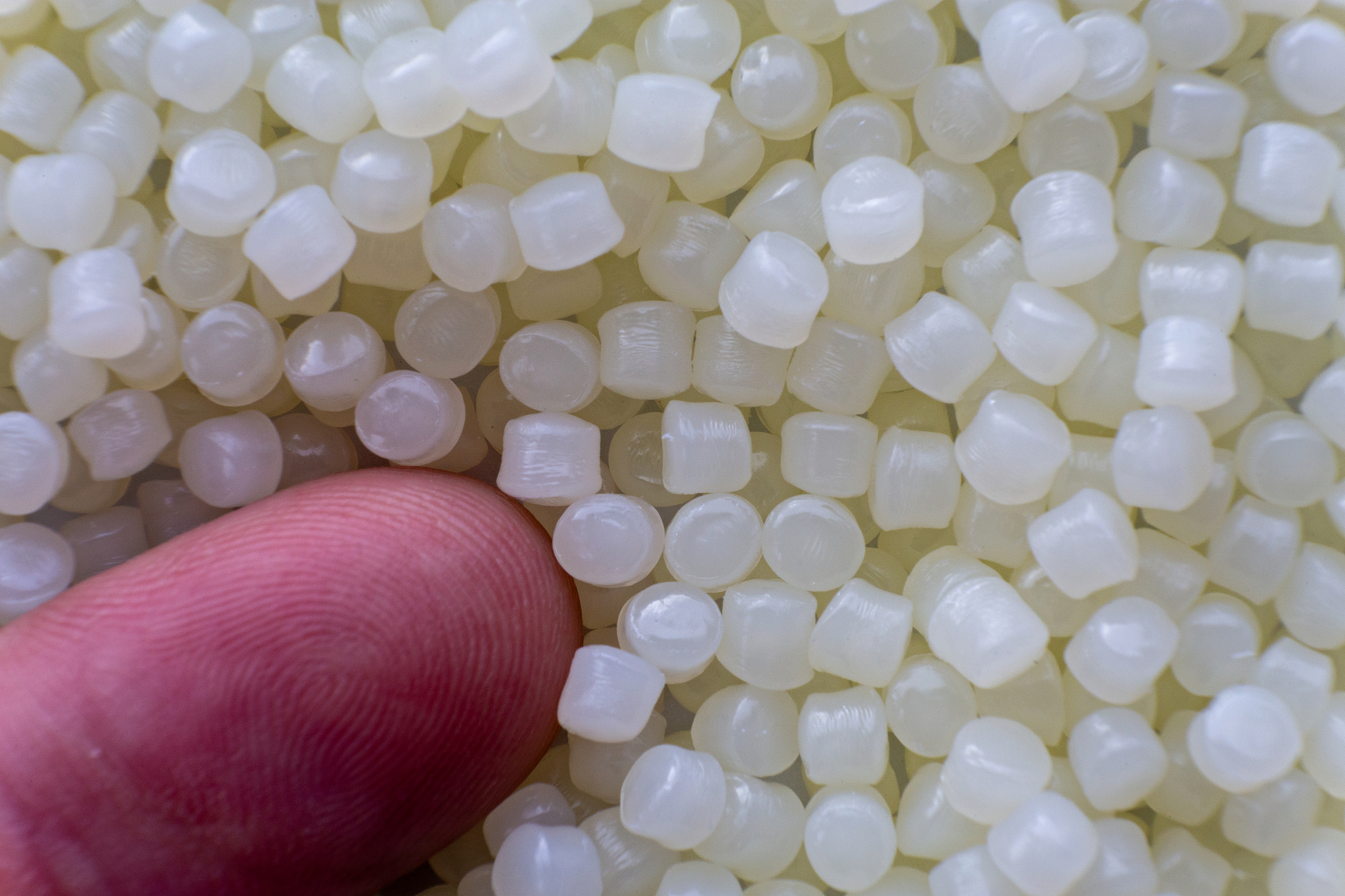 white plastic beads on wood  background, polymers bead or polyme