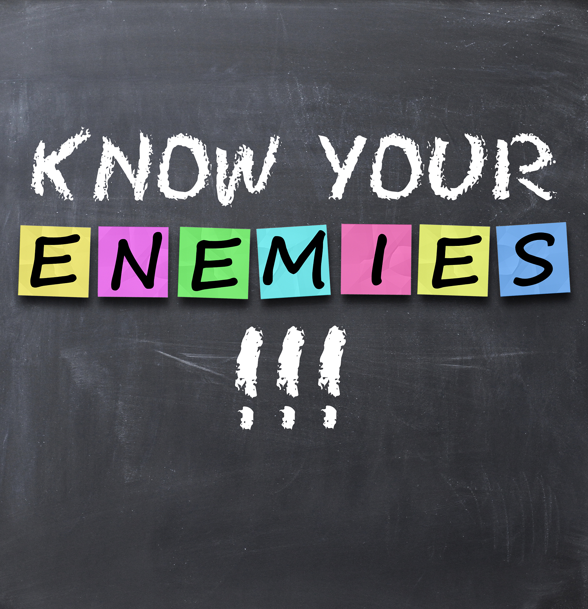 know your enemies text on blackboard with chalk and stickers