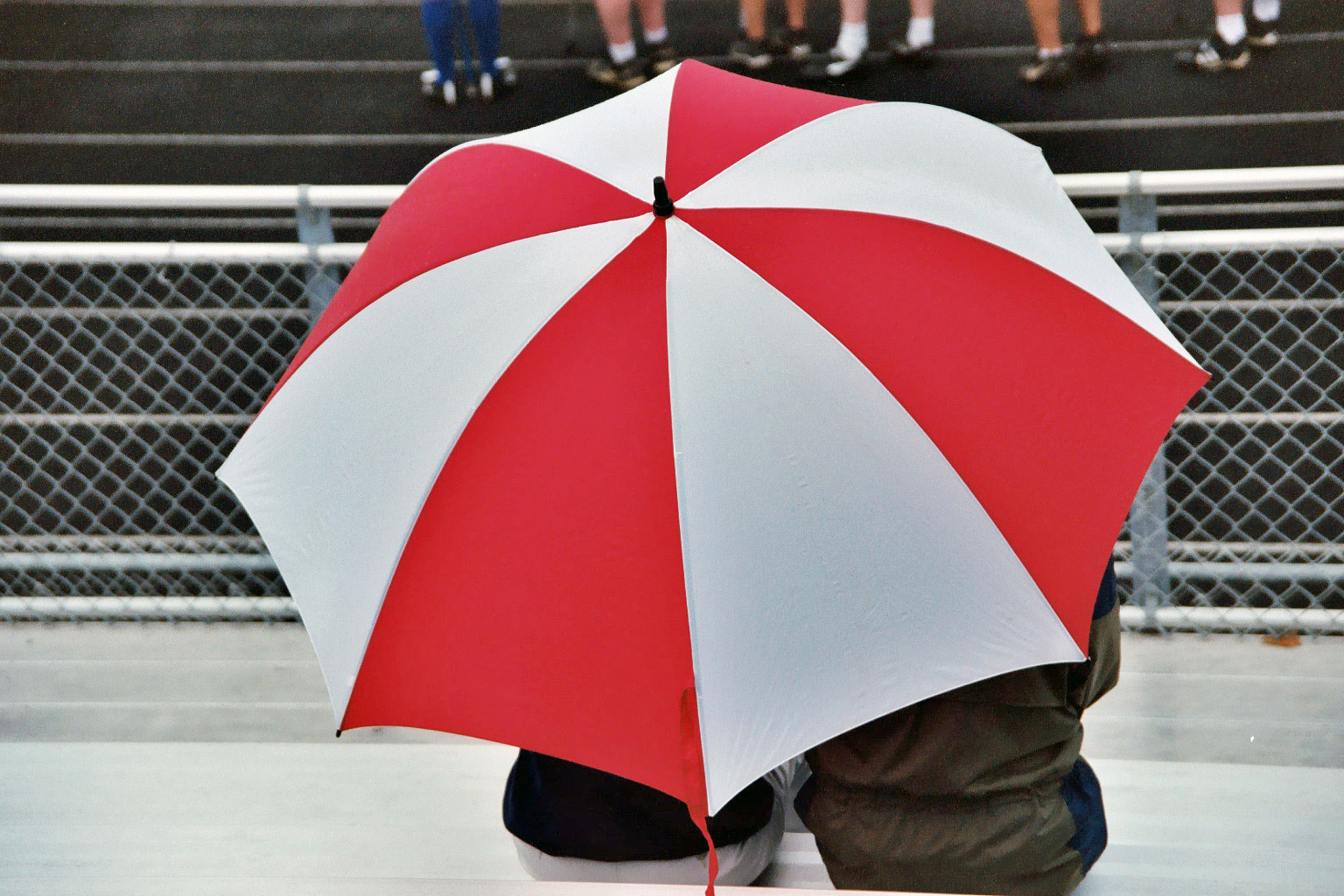 a couple huddled under an umbrella