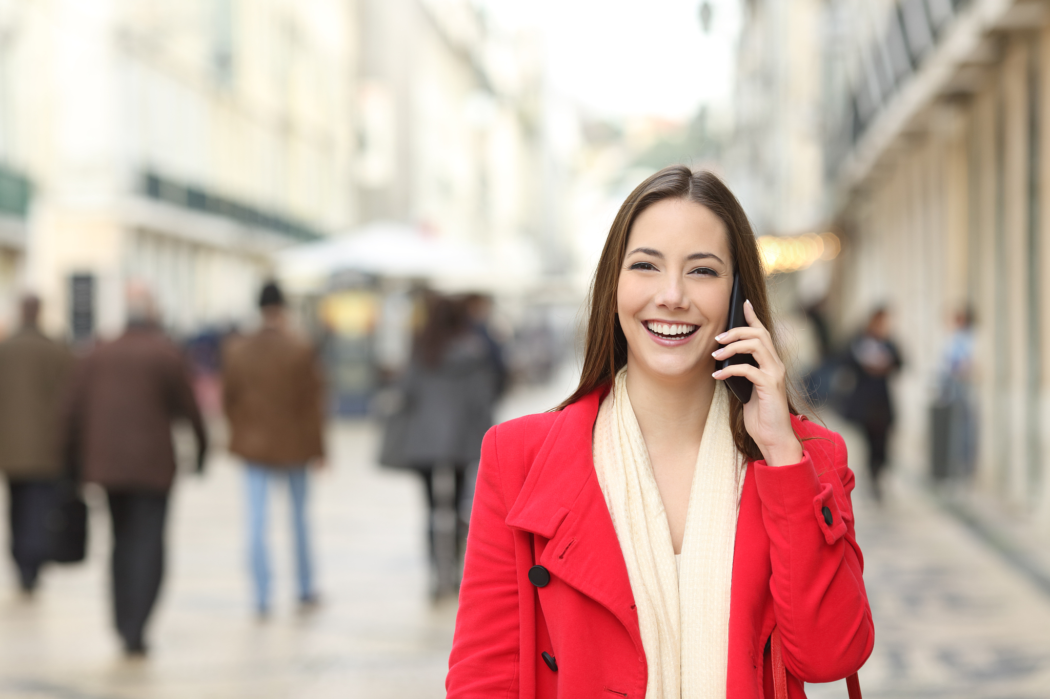 happy female walking talking on phone in the street
