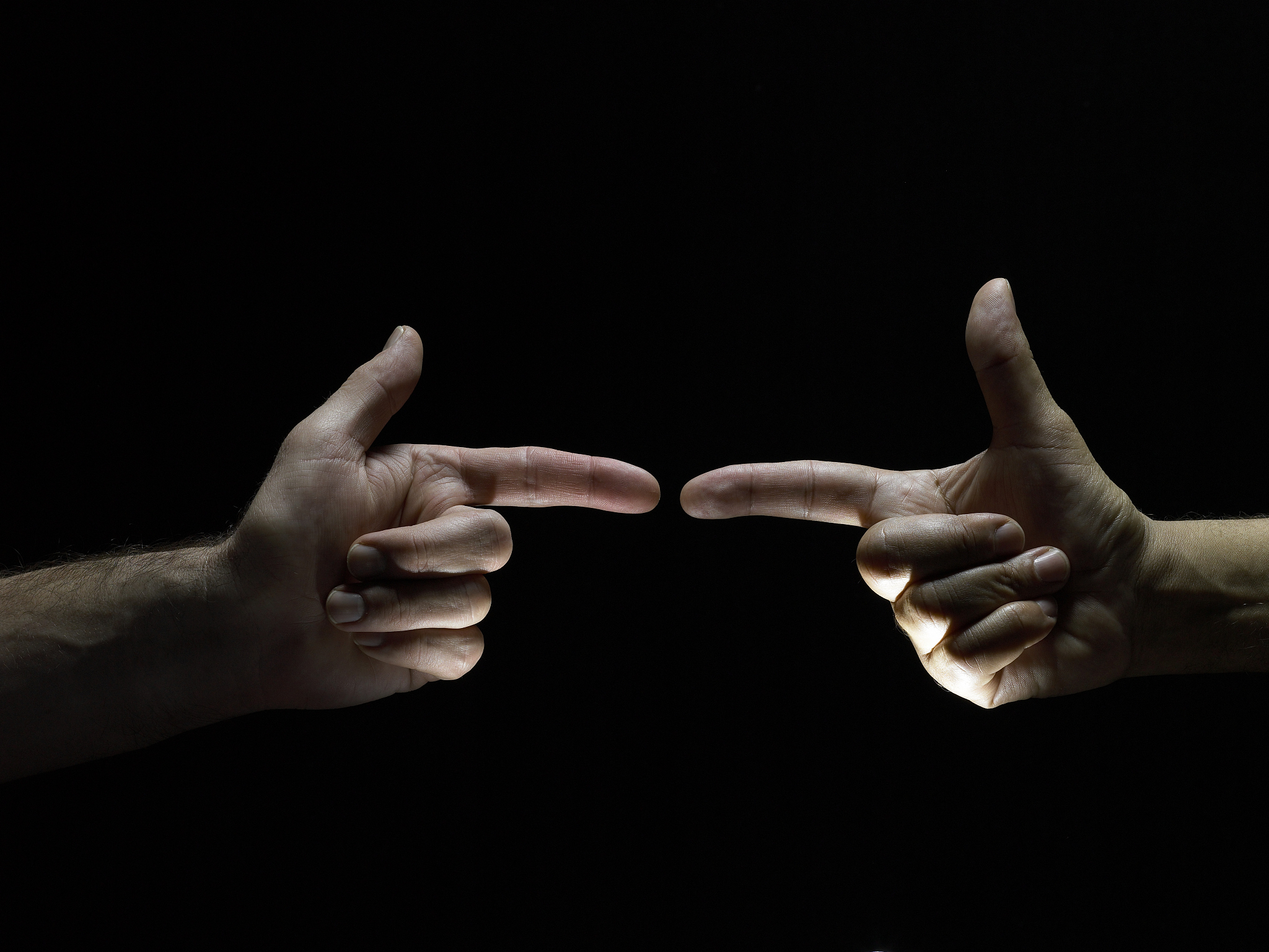 two men making gun signs, finger to finger, side view, close-up