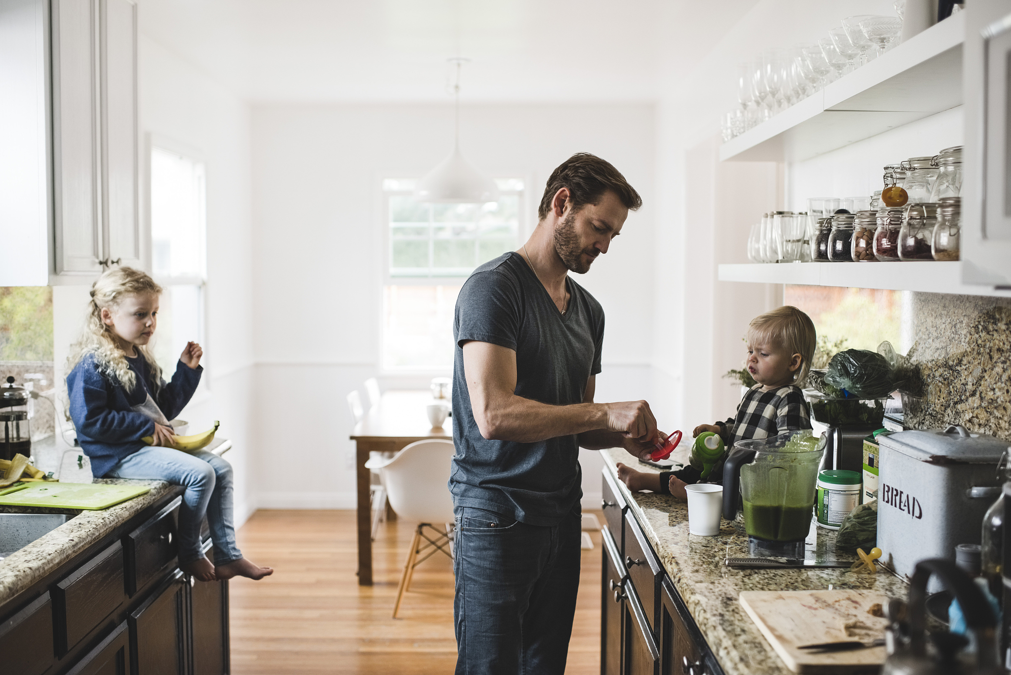 mid adult man with daughters cooking food in kitchen at home