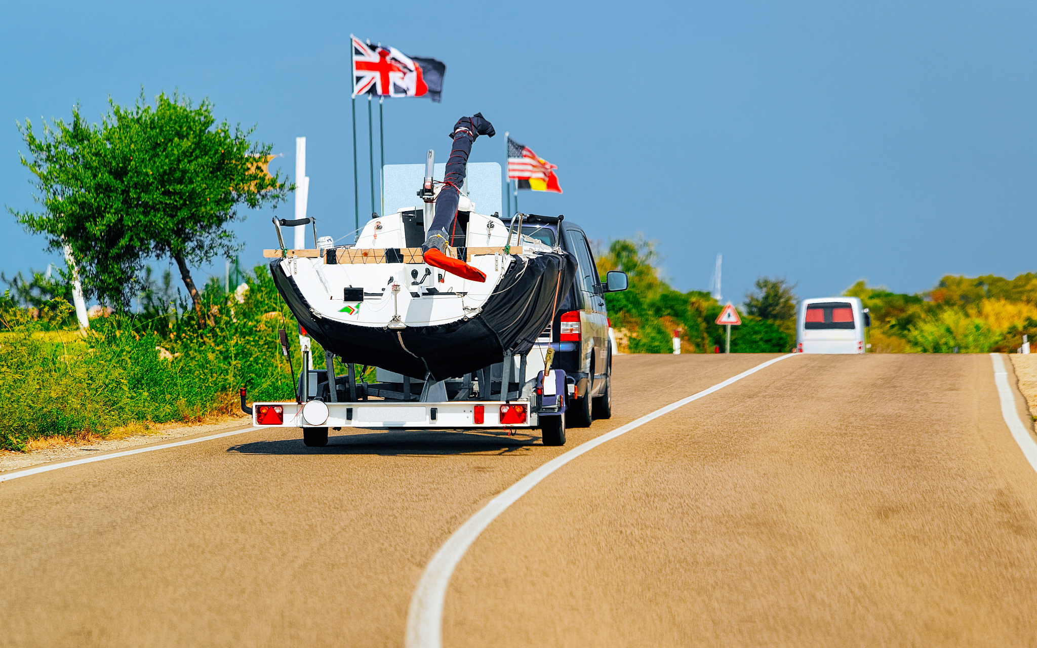 car with yacht or motor boat at road in sardinia