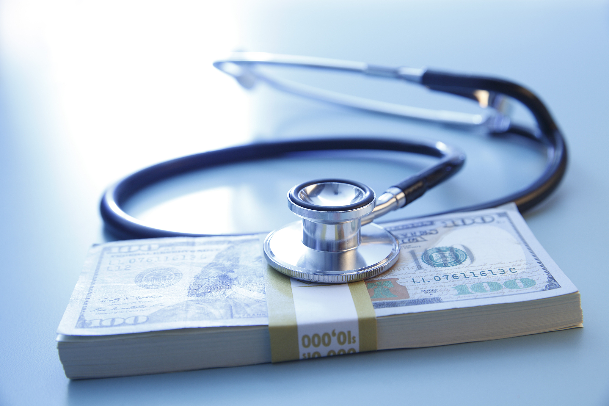 stethoscope on a stack of one hundred dollar bills
