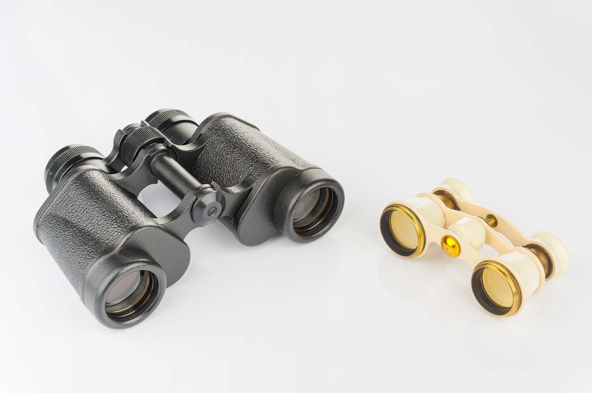 old opera glass and modern binoculars on white background