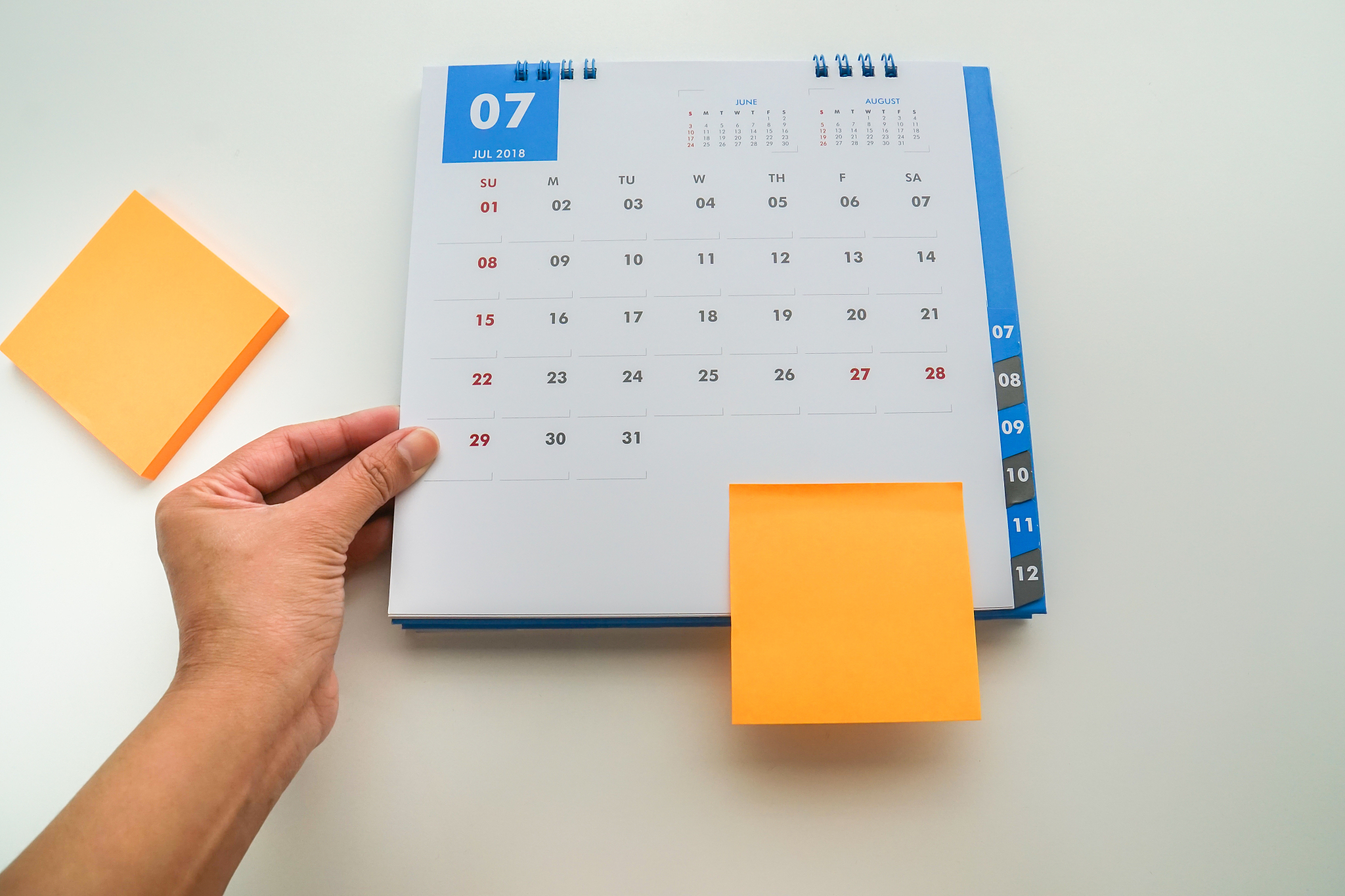 isolated close up woman hand hold july 2018 calendar