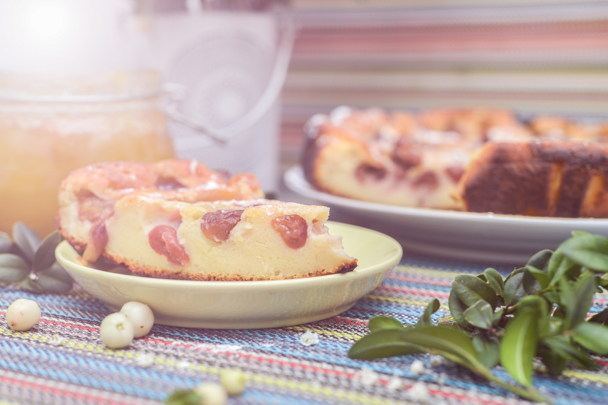 cherry pie on the colorful tablecloth with twig and honey