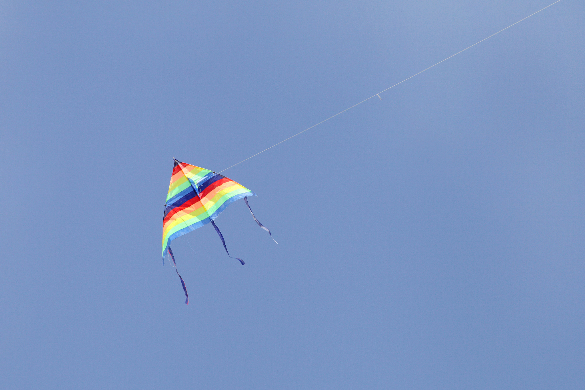 colorful triangular kite flying in the sky