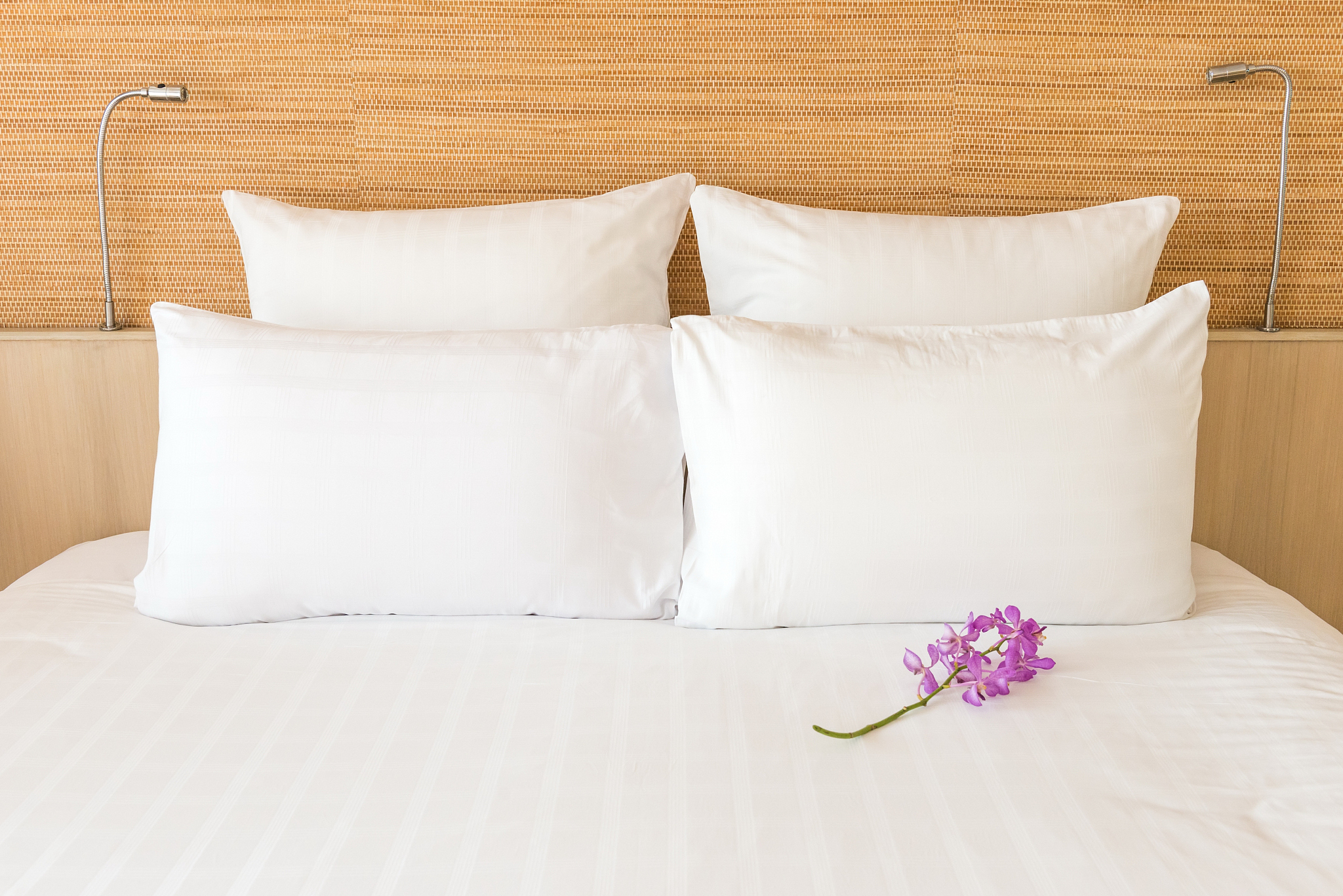 white bed with 4 pillows and 2 head lights