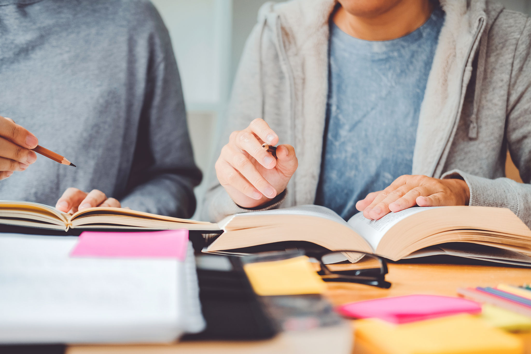high school or college students studying and reading together in