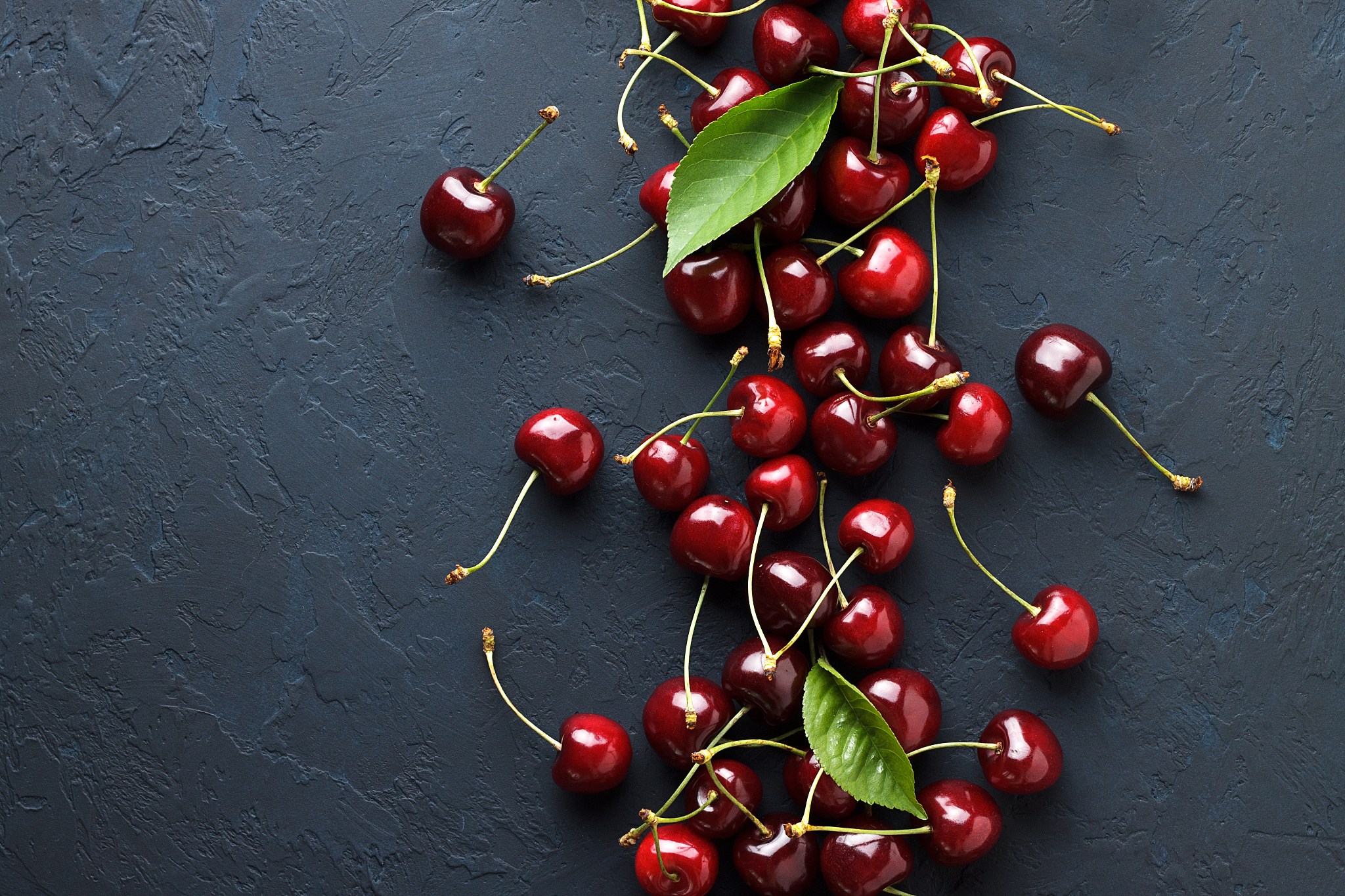 berry backgrounds with fresh ripe sweet cherries on dark blue st
