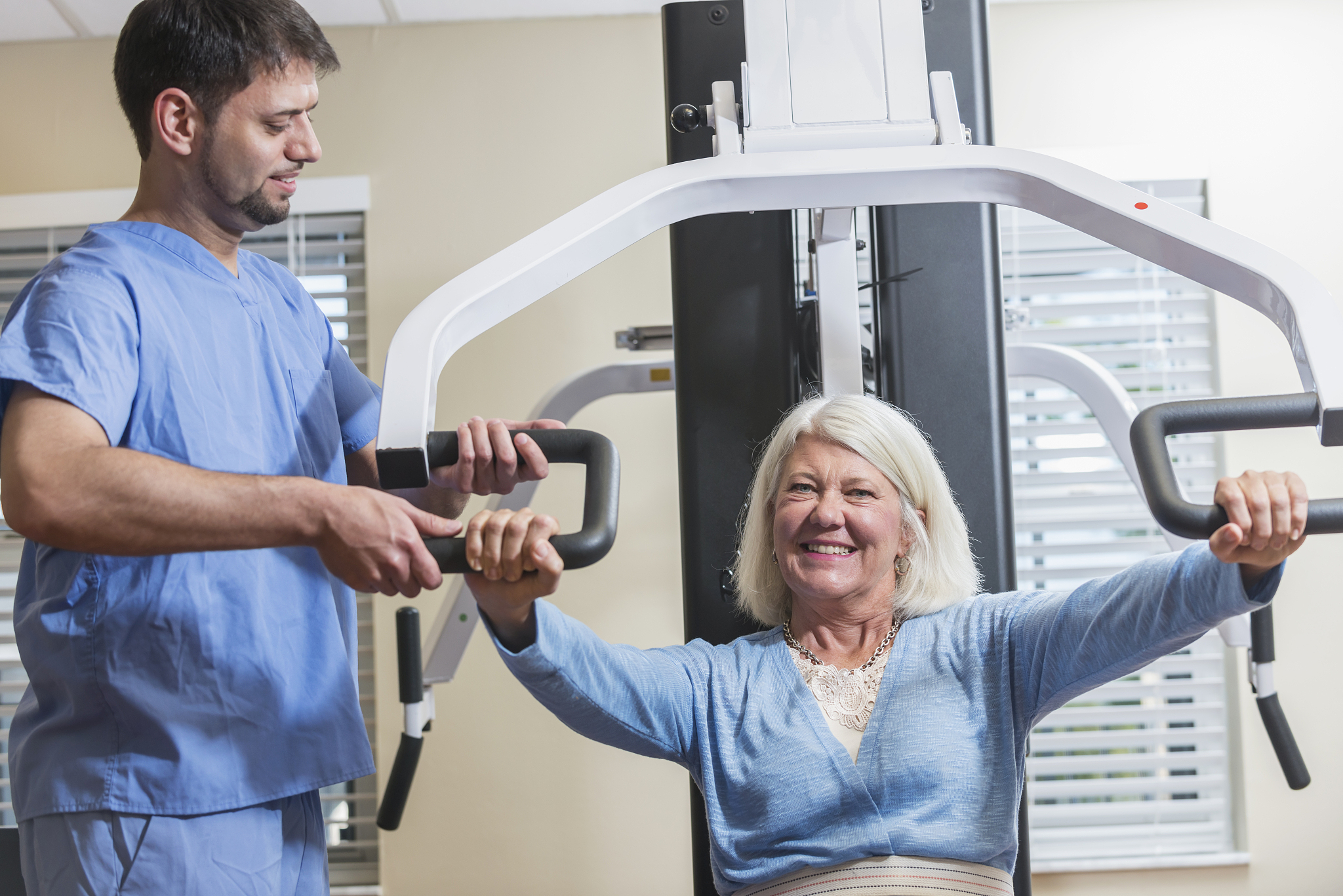 hispanic physical therapist helping female patient