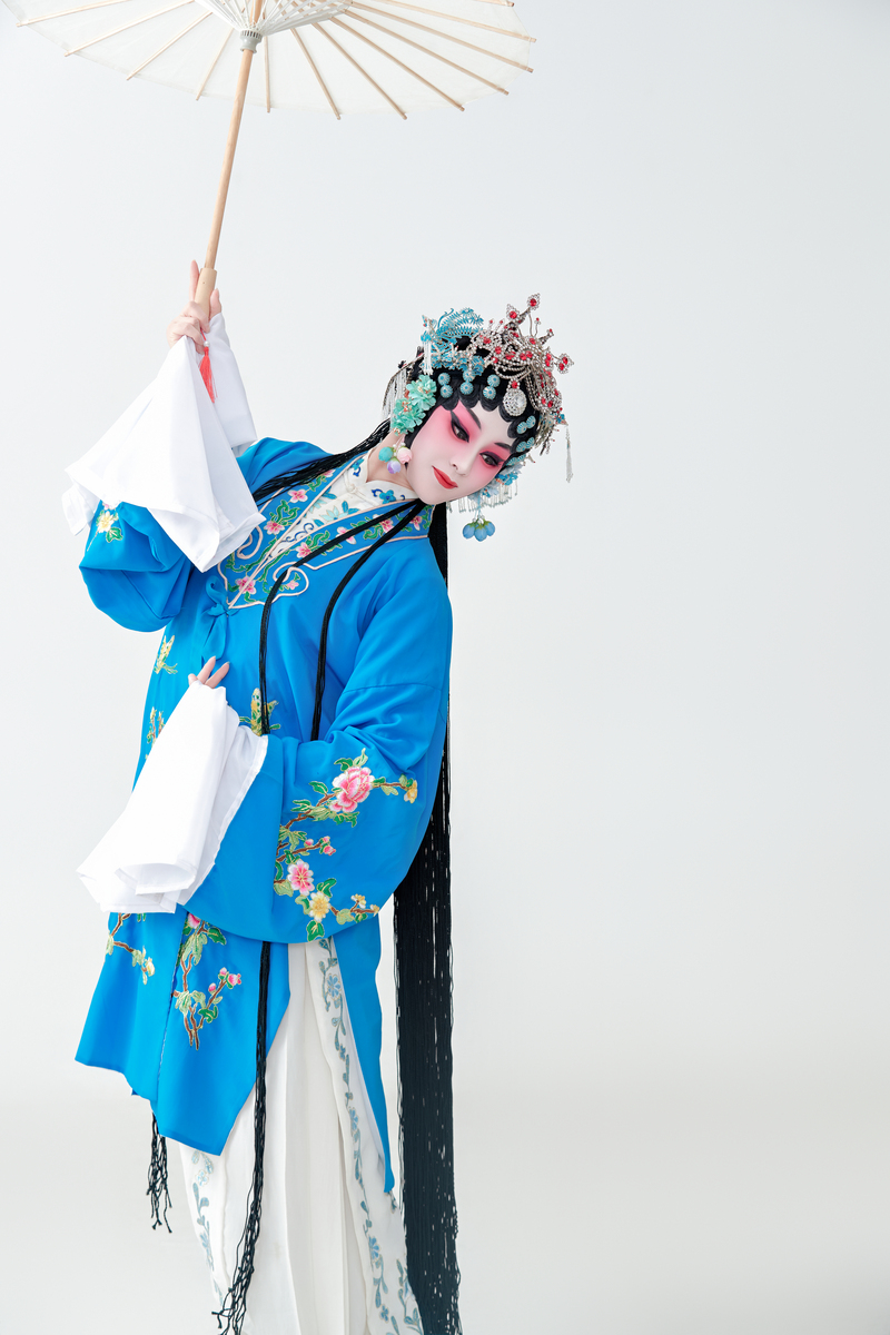 一位扮演青衣或花旦的京剧女演员,手持油纸伞.