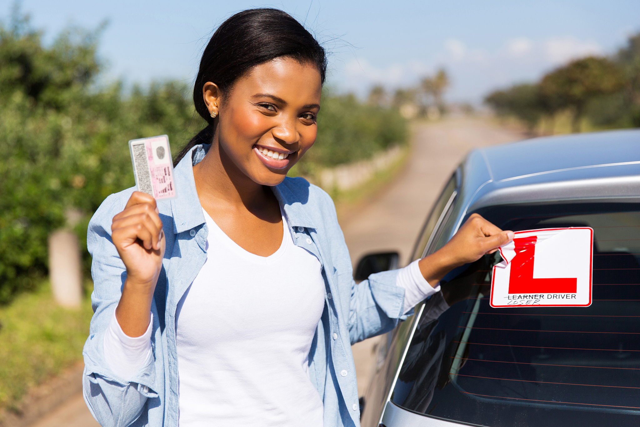 african woman removing learner driver sign