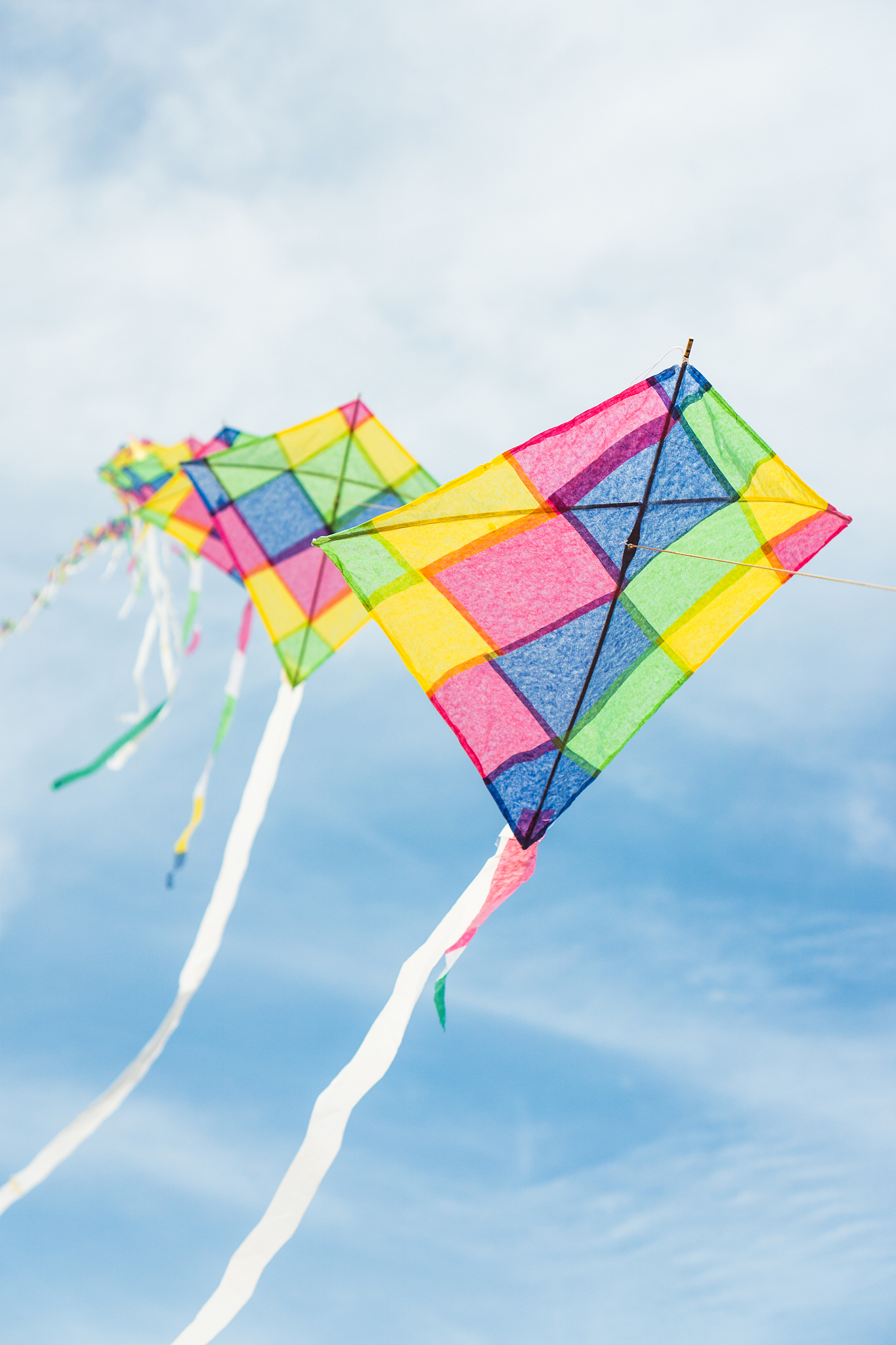 colorful long line kites flying in blue sky