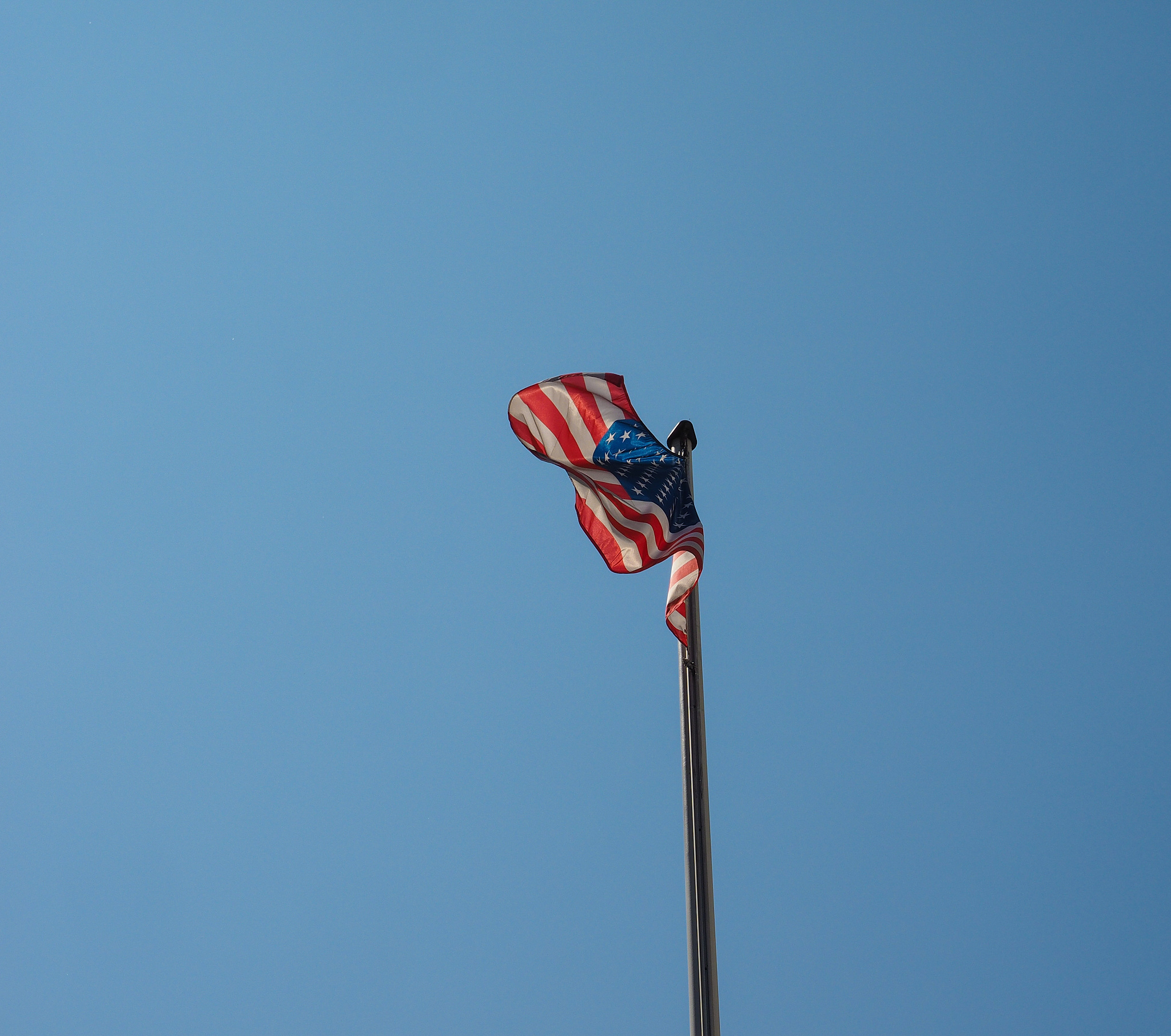 american flag of united states of america over blue sky