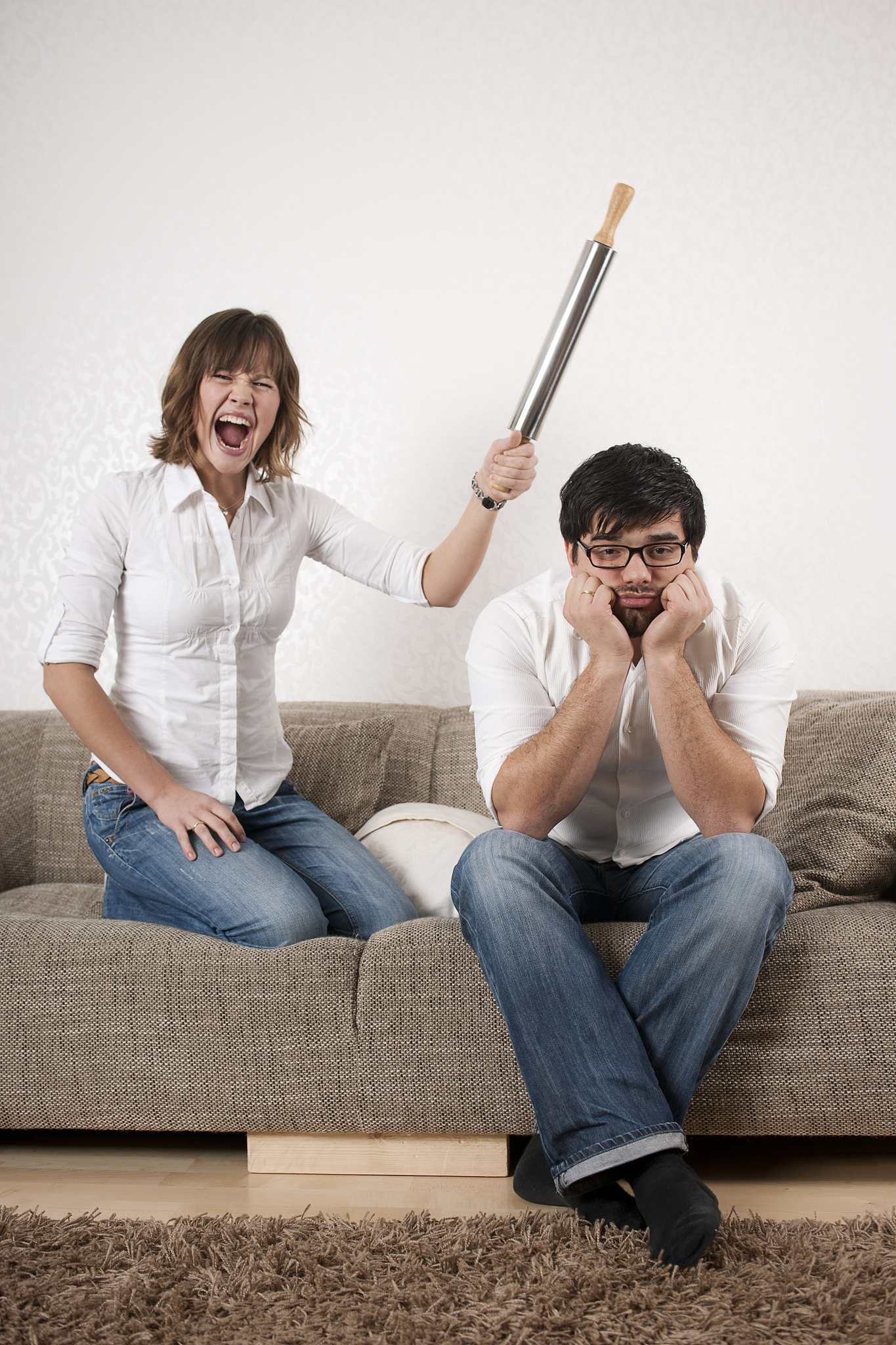woman is beating her husband with rolling pin