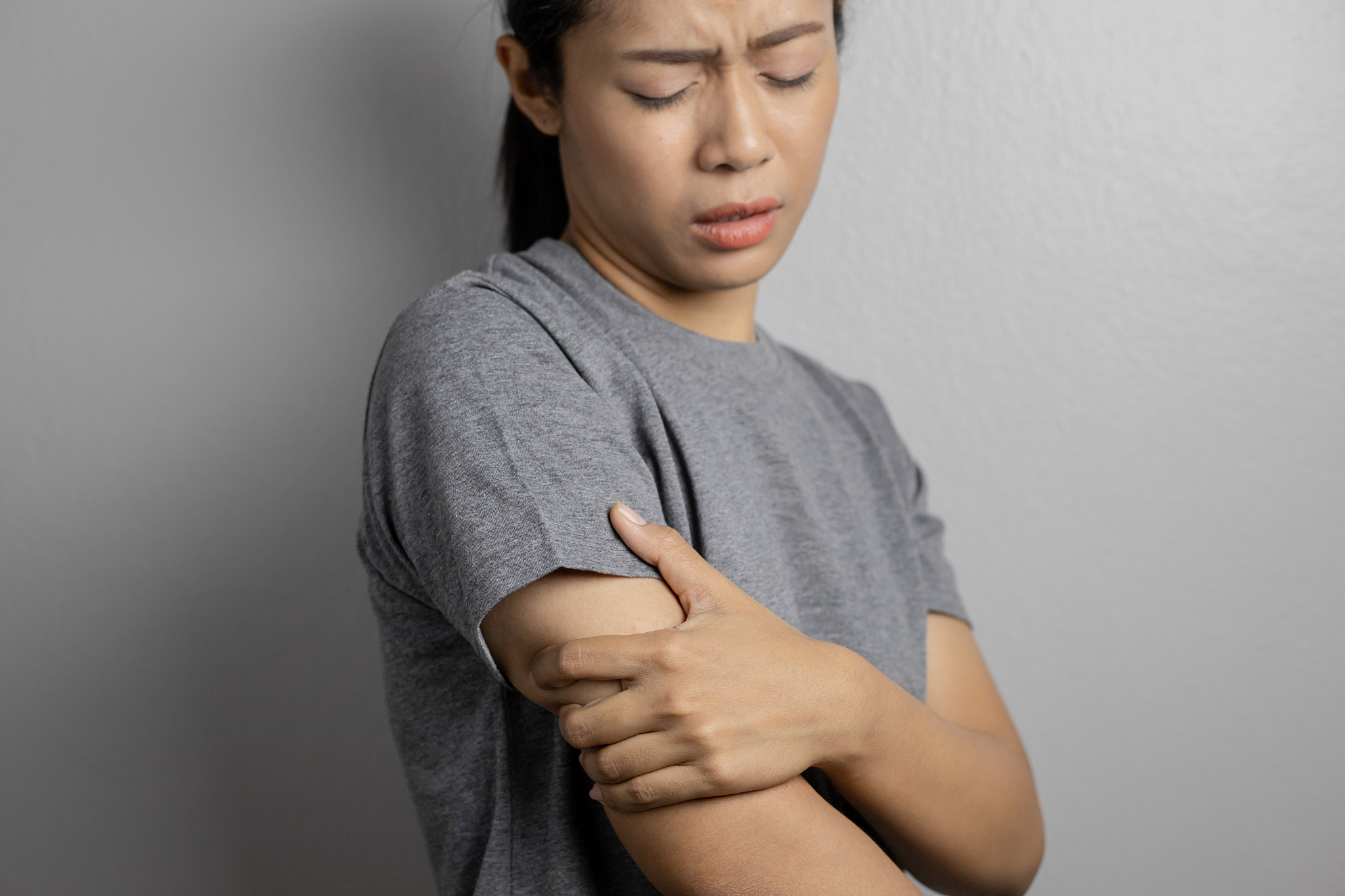 woman suffering from pain in arm.