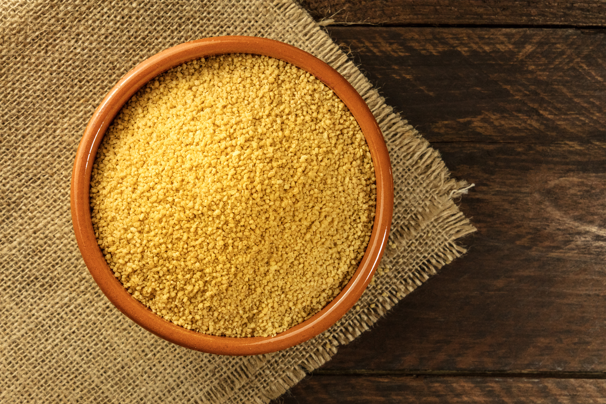 bowl of couscous on rustic textures with copyspace