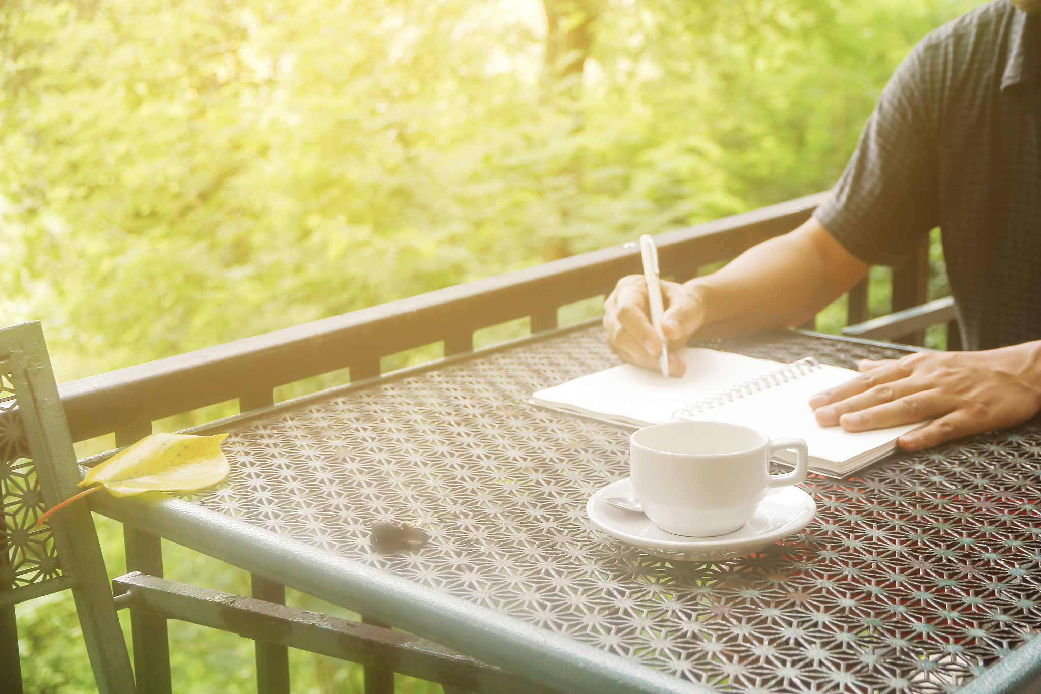 stock photo : coffee cup with closeup man writing a notebook on 