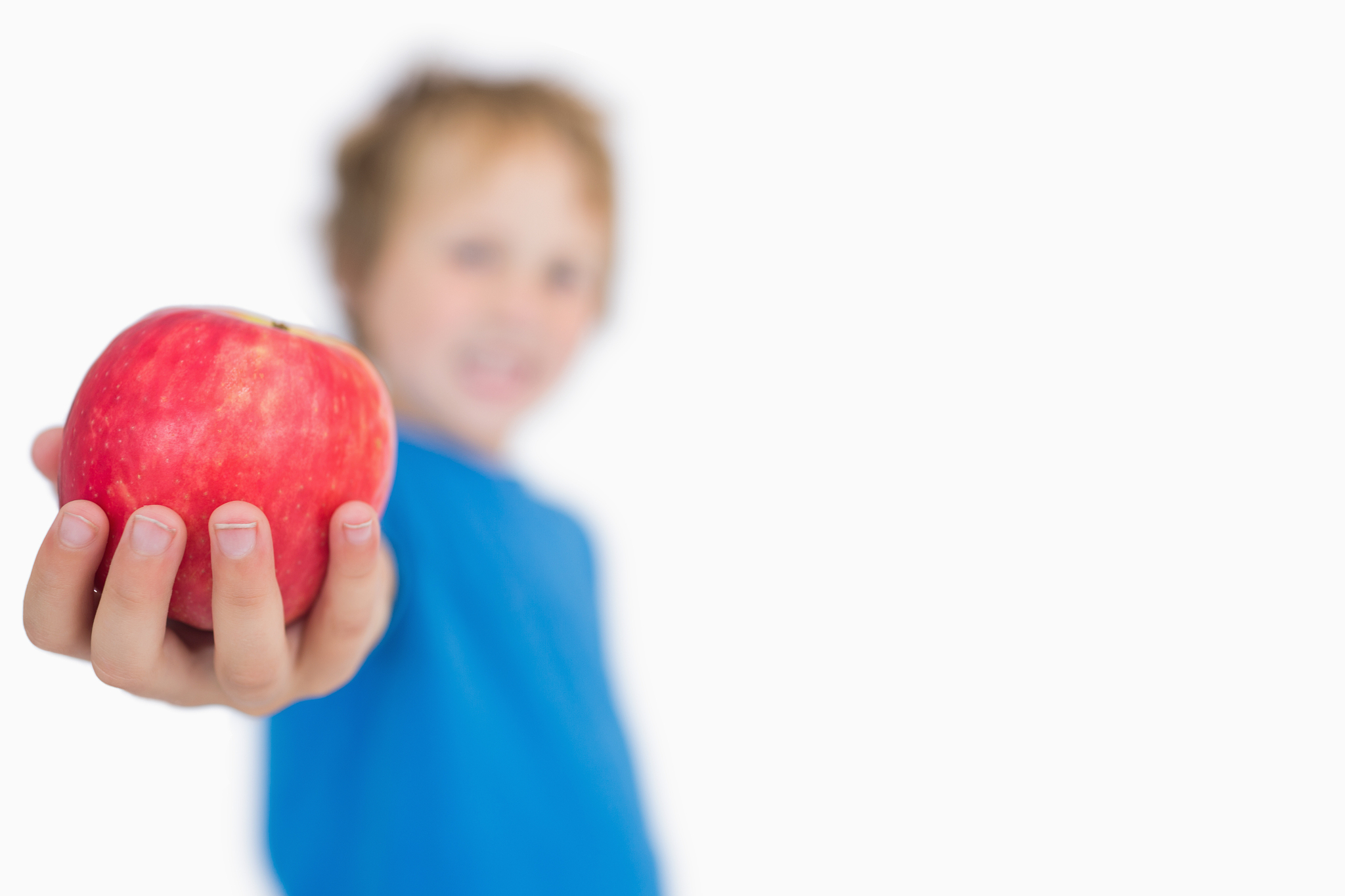 young boy holding out a apple