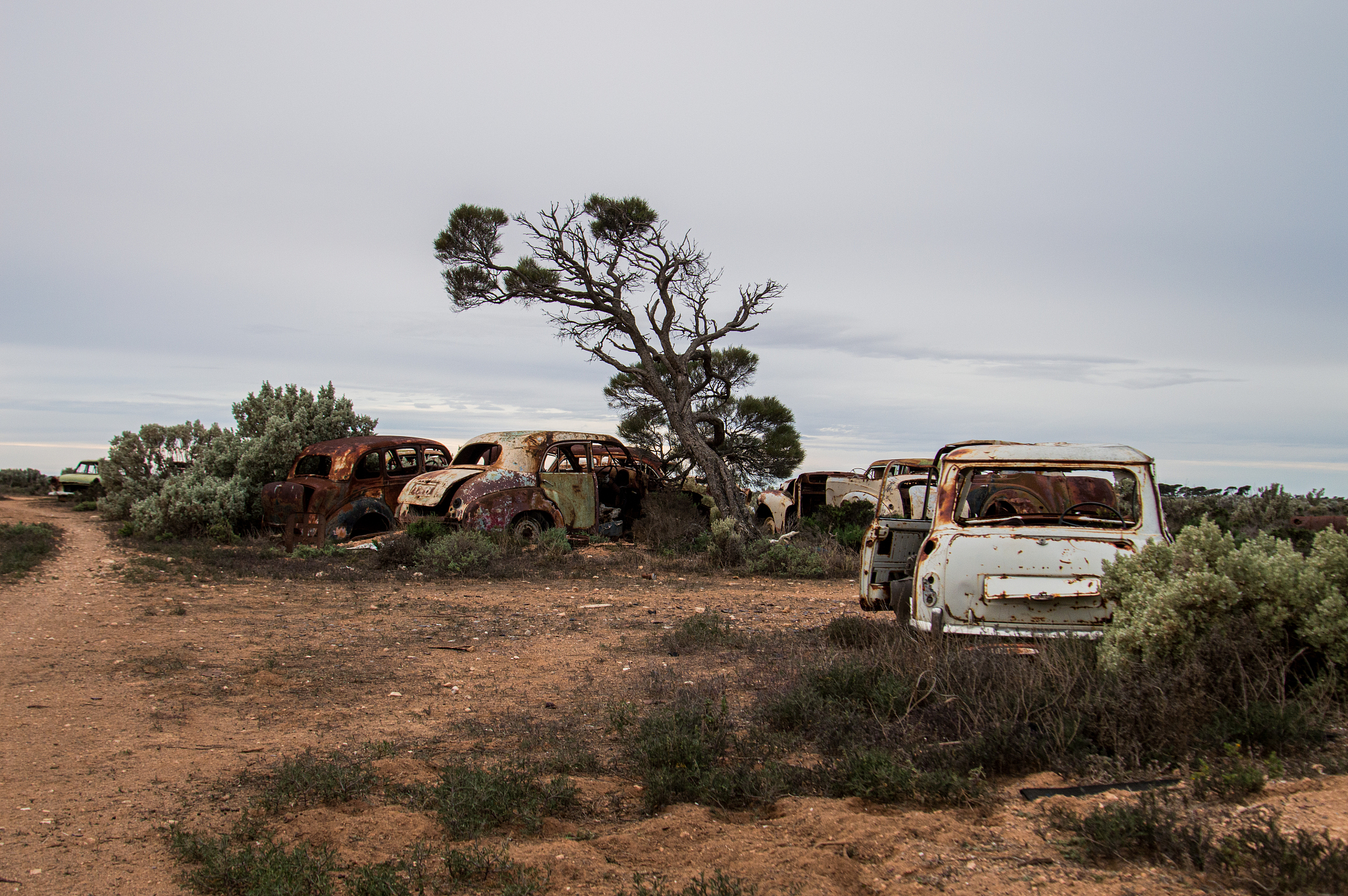 abandoned vehicles on field against sky outback australia