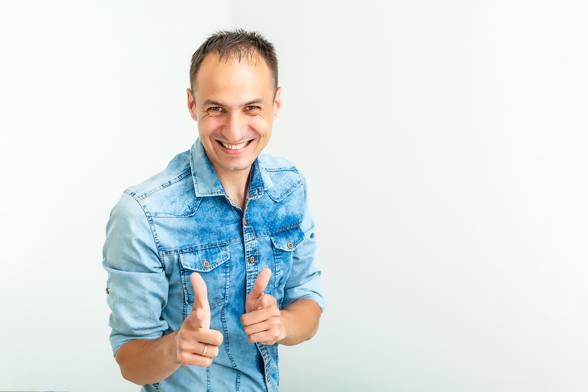 handsome young man smiling with arms crossed on white background