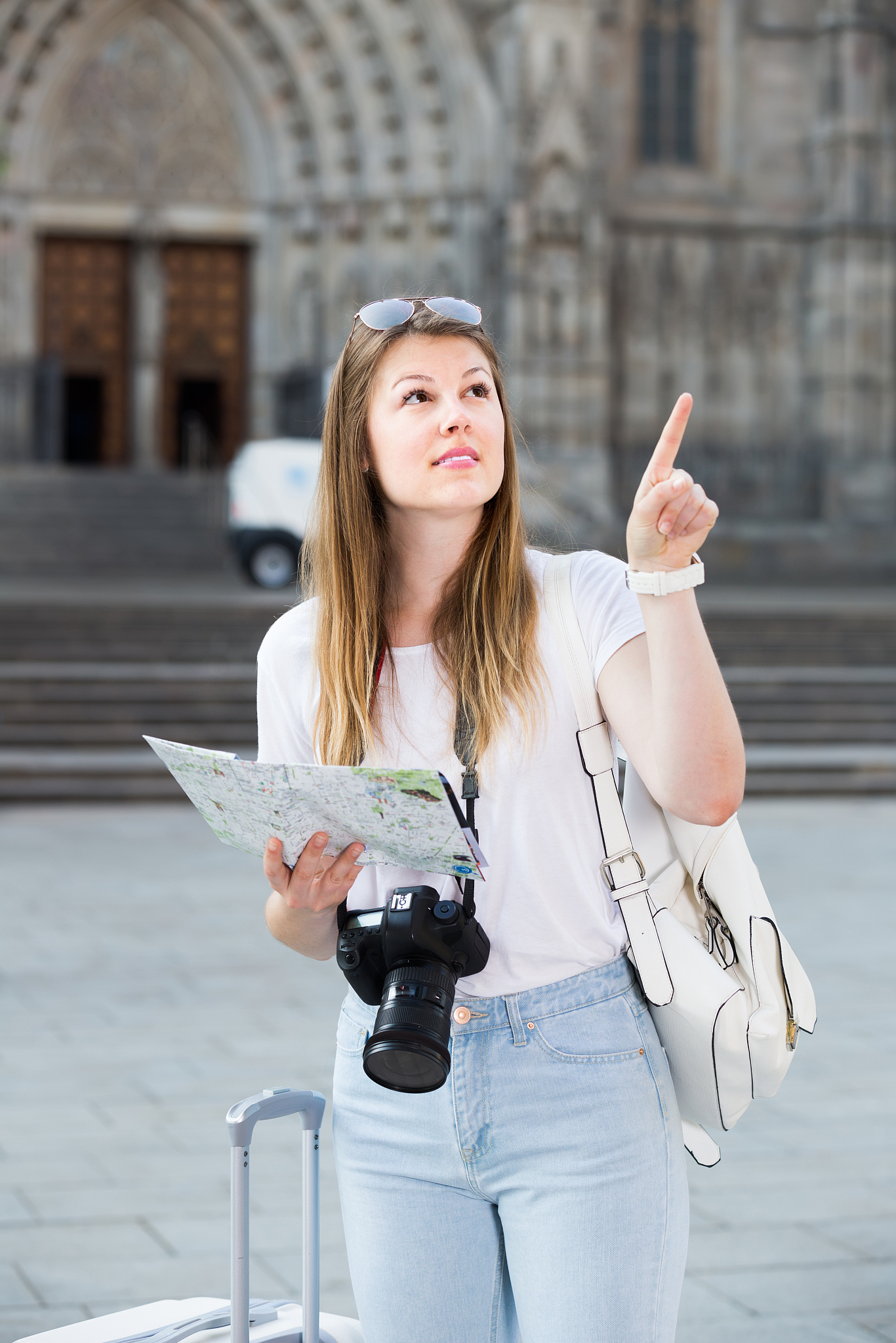 blond positive young woman holding  map in hands