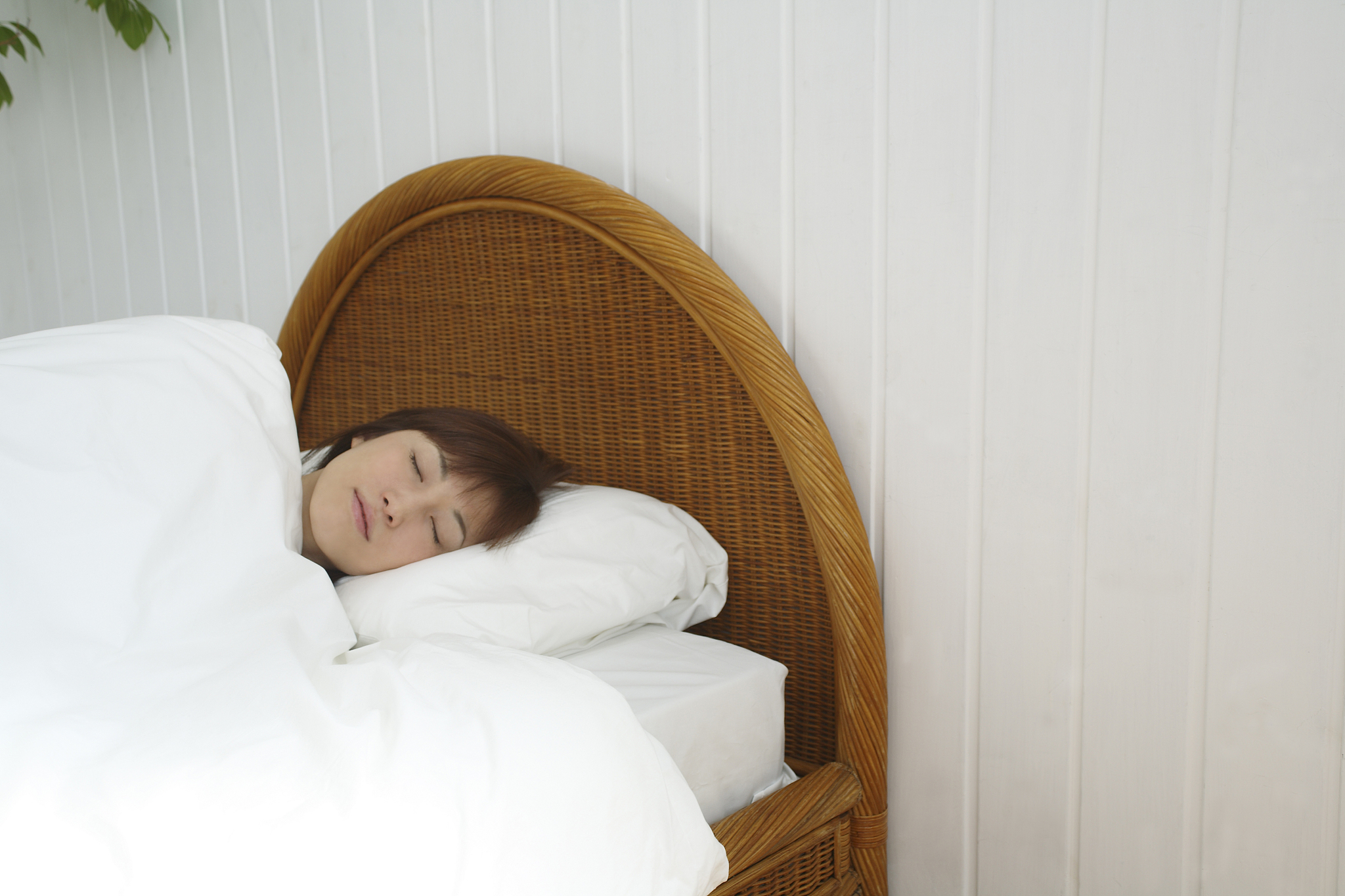 young woman sleeping in bed, front view