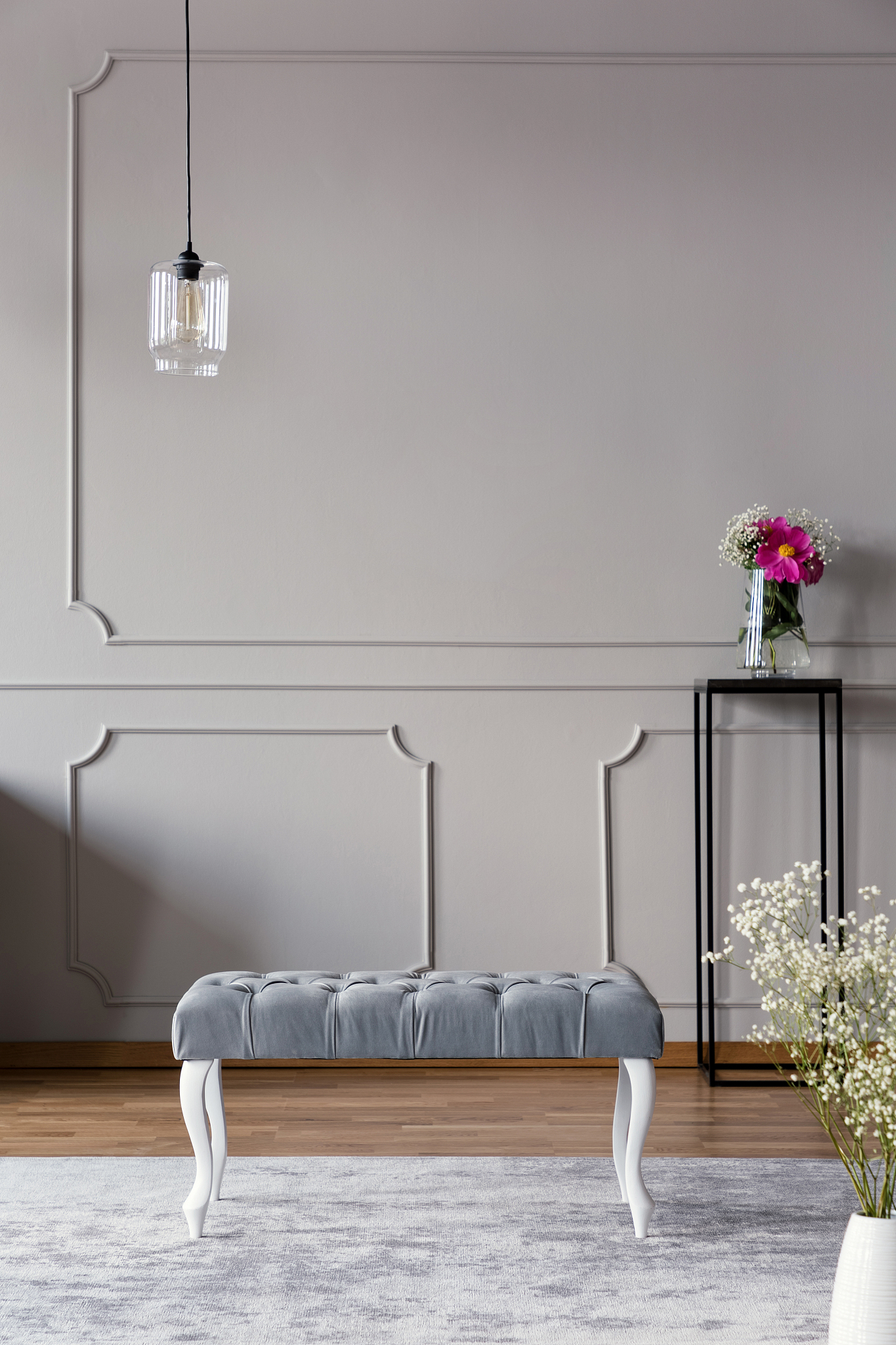 grey hallway interior with a bench, lamp and flower in a vase on