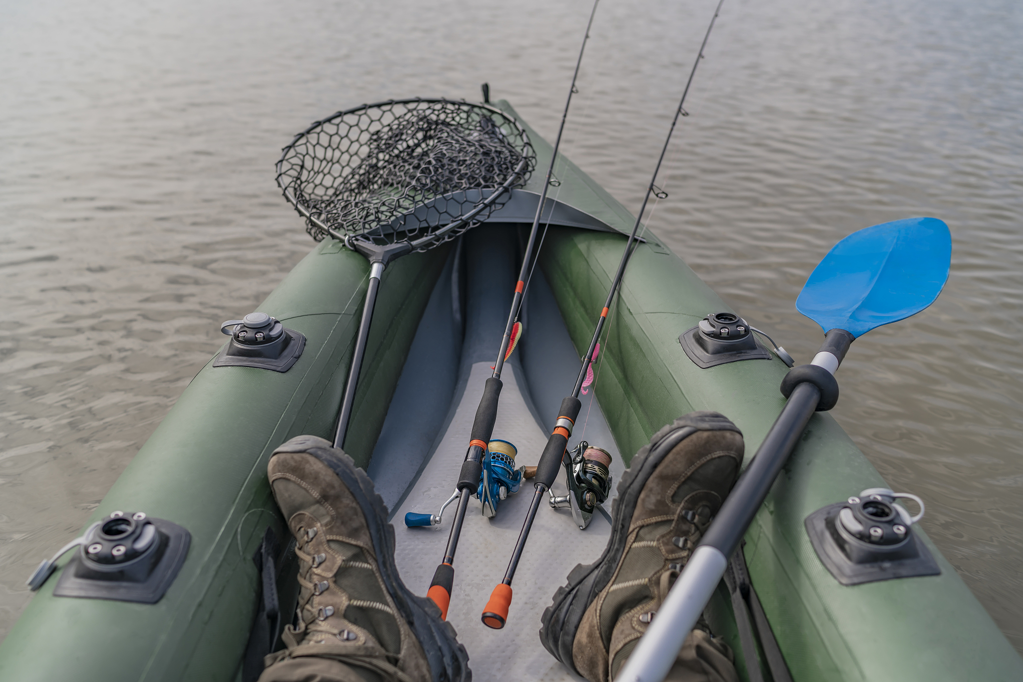 kayak fishing at lake. legs of fisherman on inflatable boat with