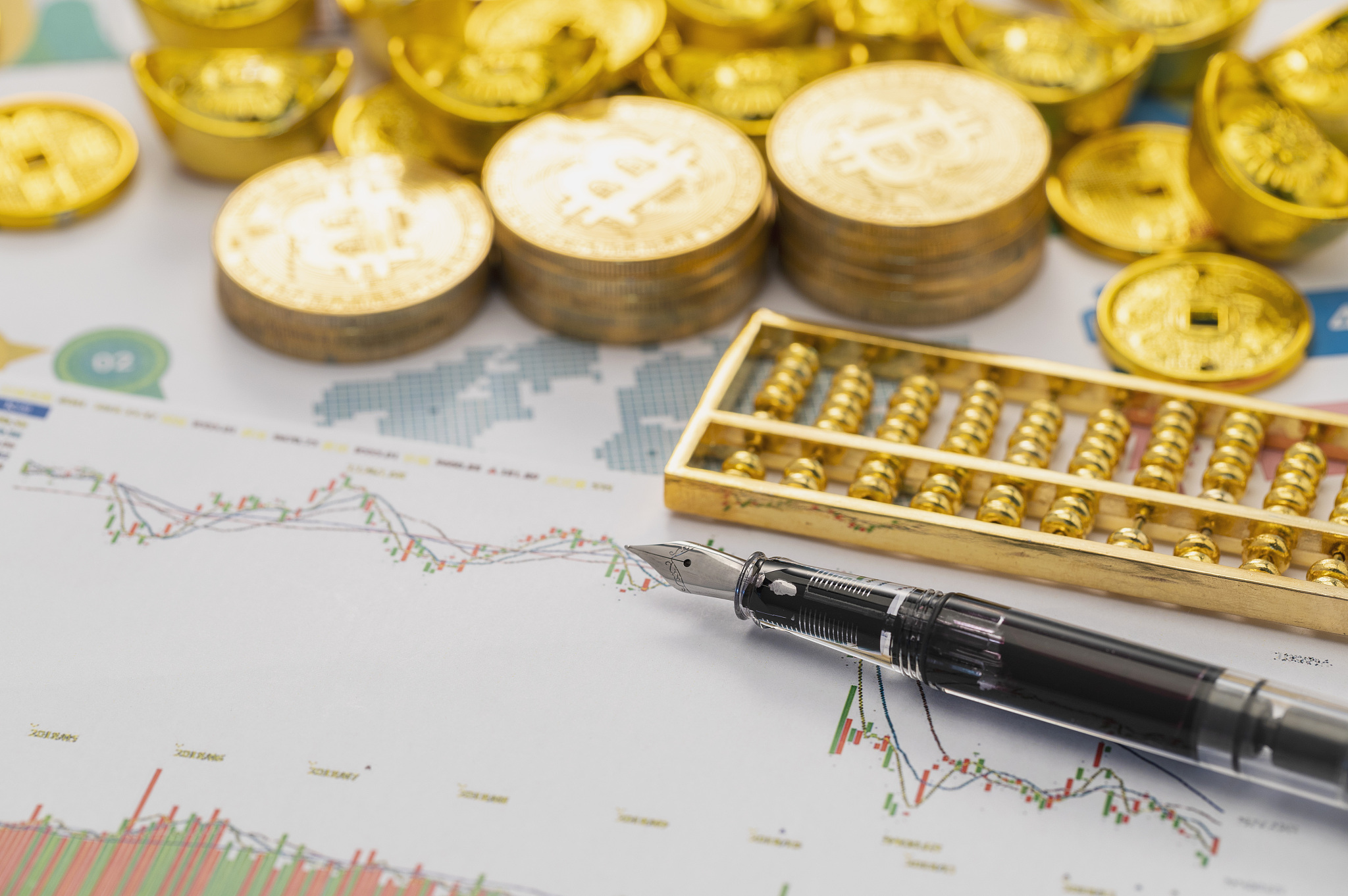 金融指数图纸上放着算盘钢笔和大量金币