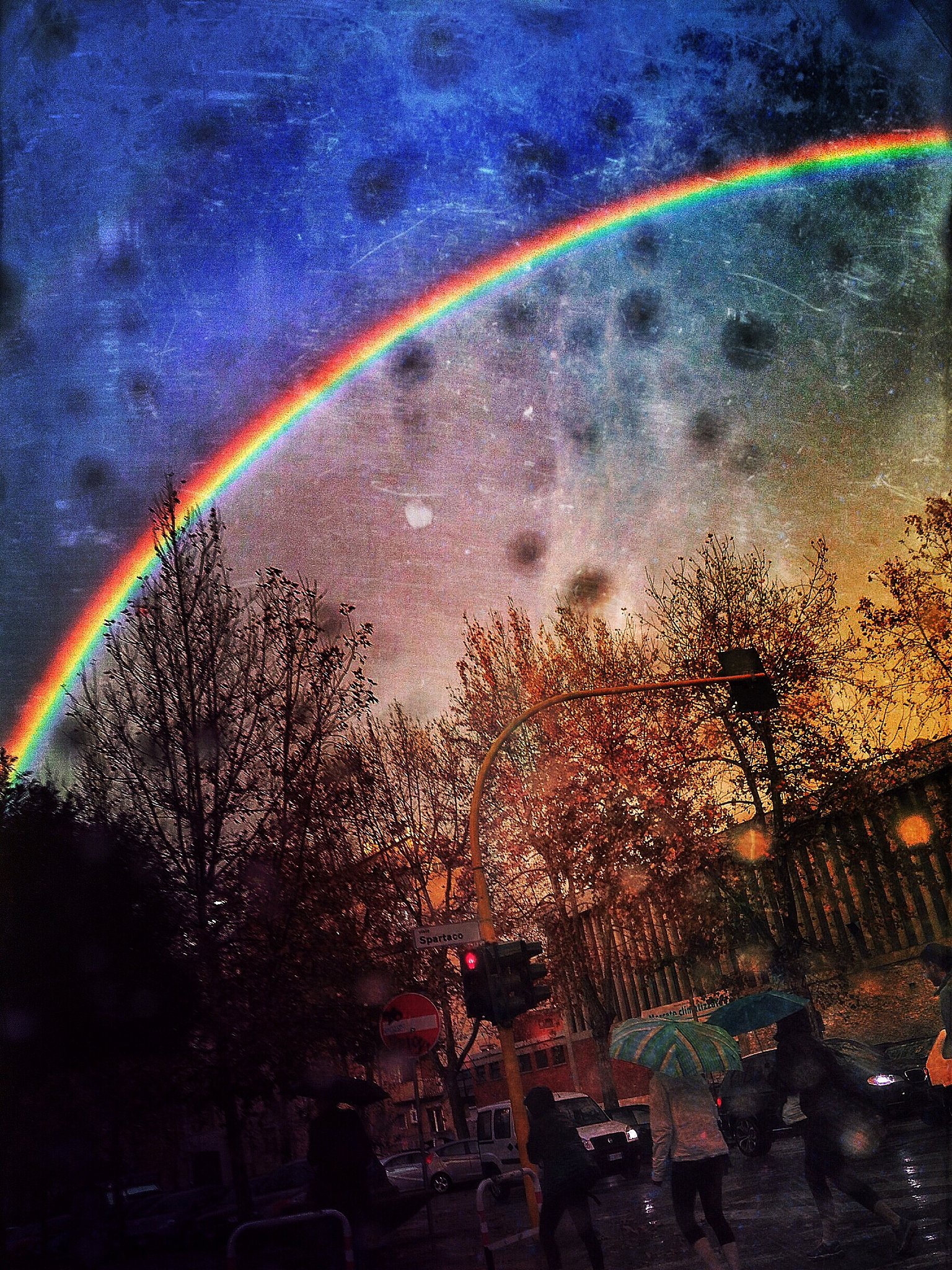 low angle view of rainbow against sky during monsoon at sunset
