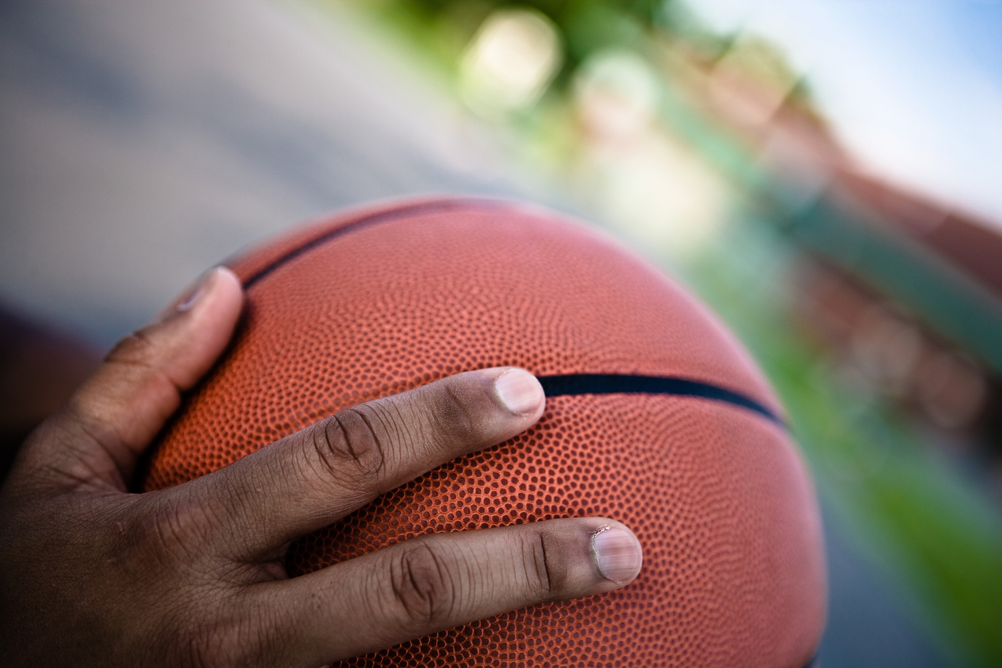 close-up of hand of man on basketball outdoors