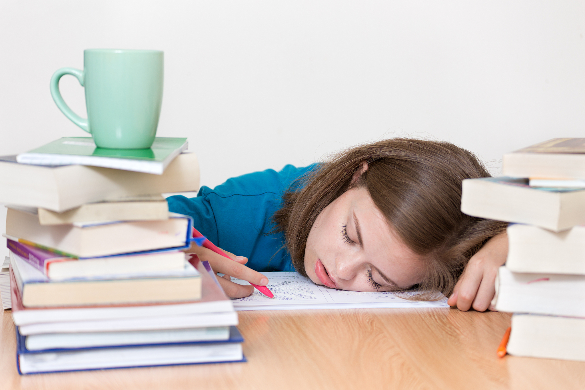 young caucasian girl woman sleeping with many books at school or