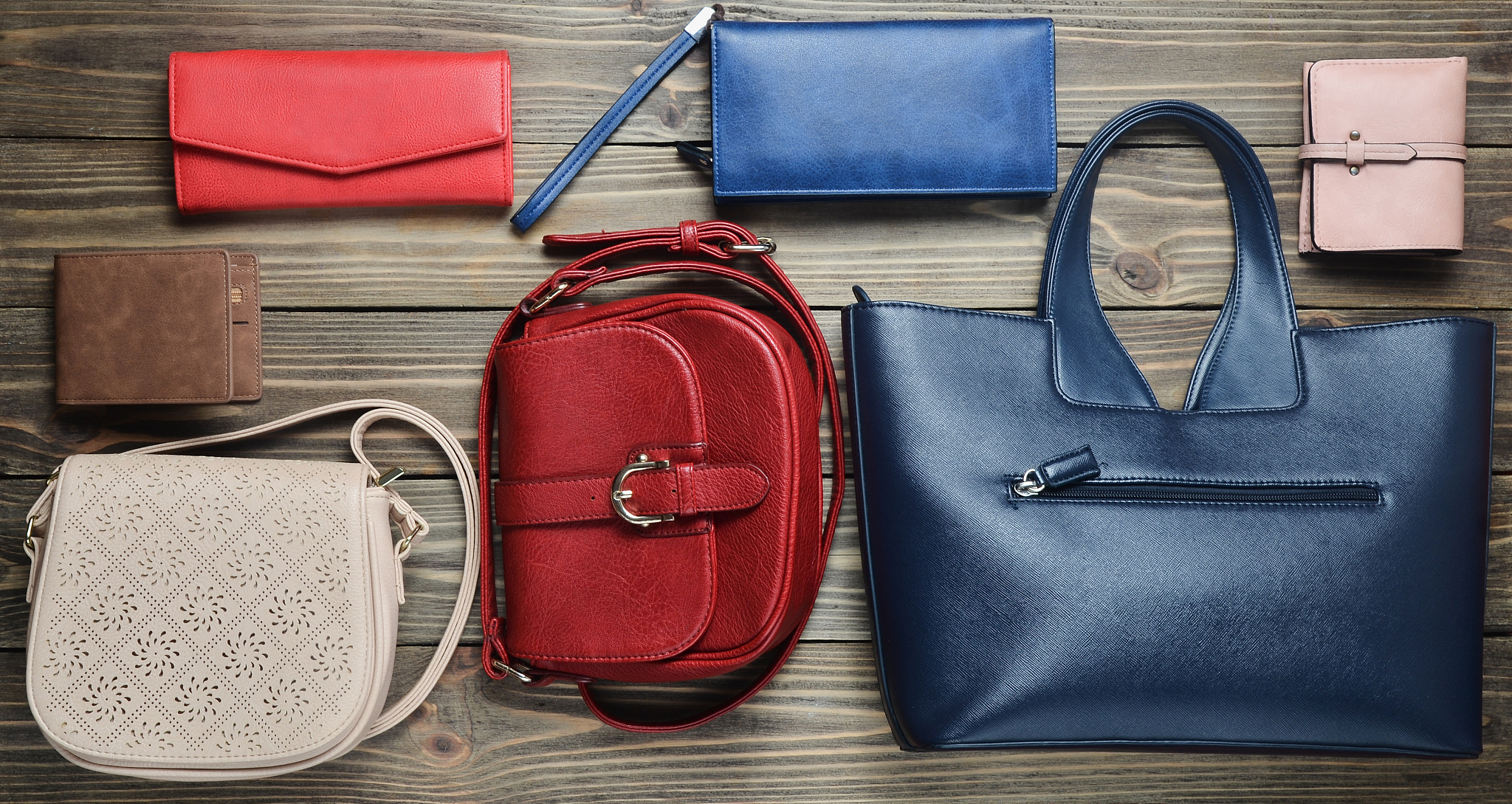 many women's bags and purses on a wooden background. top view.