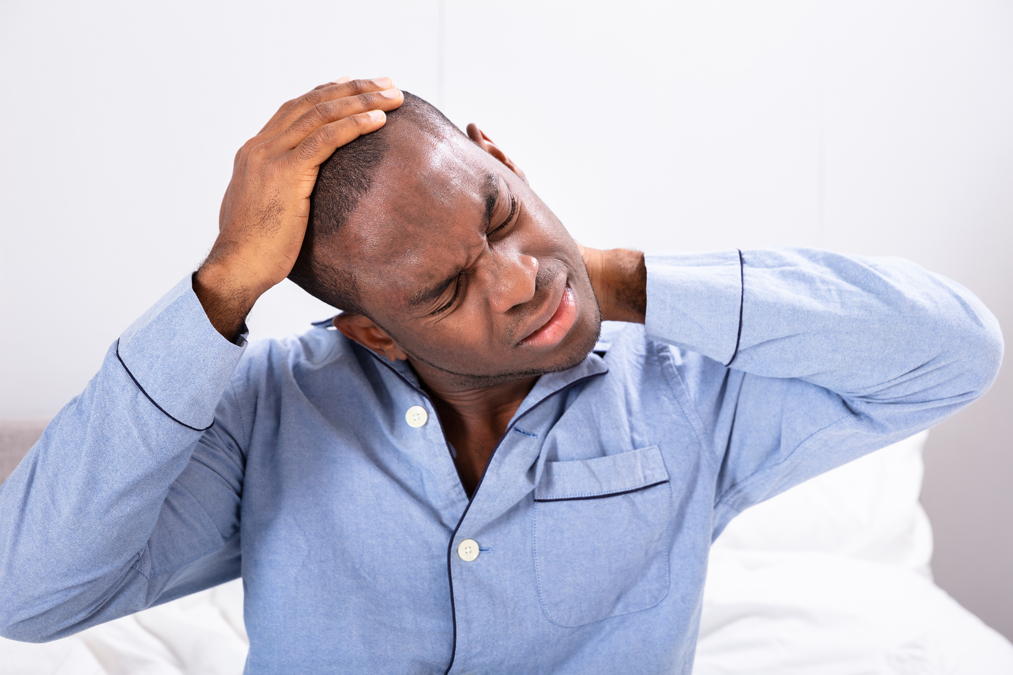 man suffering from neck pain