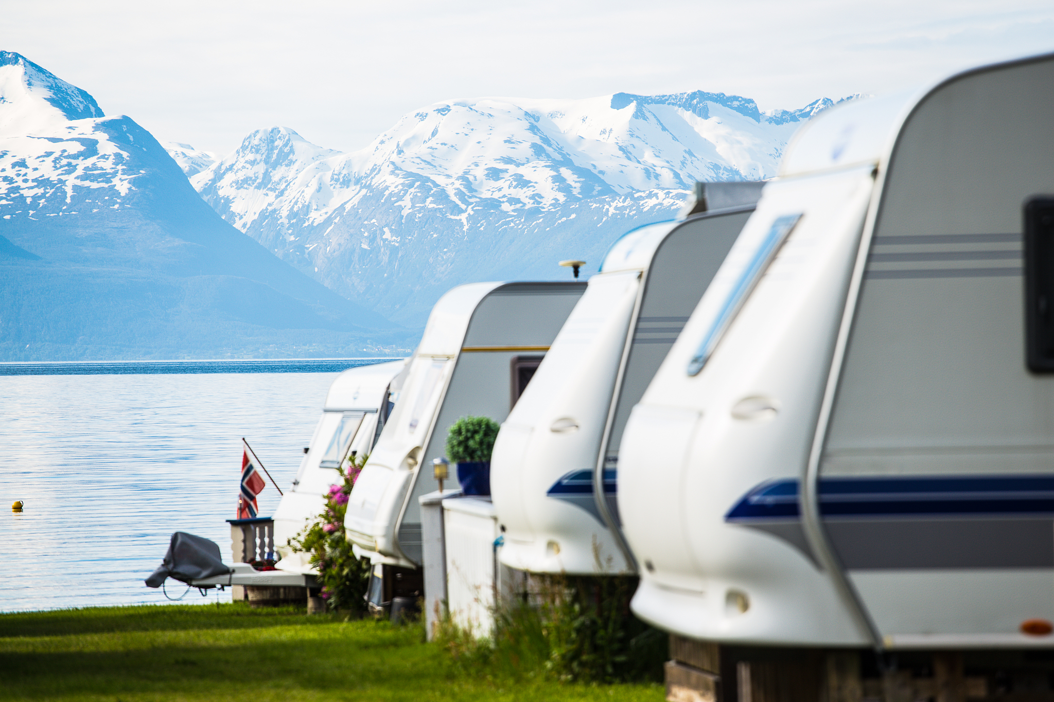 camping site with the blurred camper caravan cars on a fjord sho