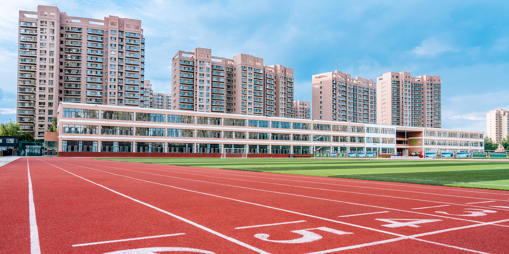 体育场的红色跑道和远处的高楼建筑