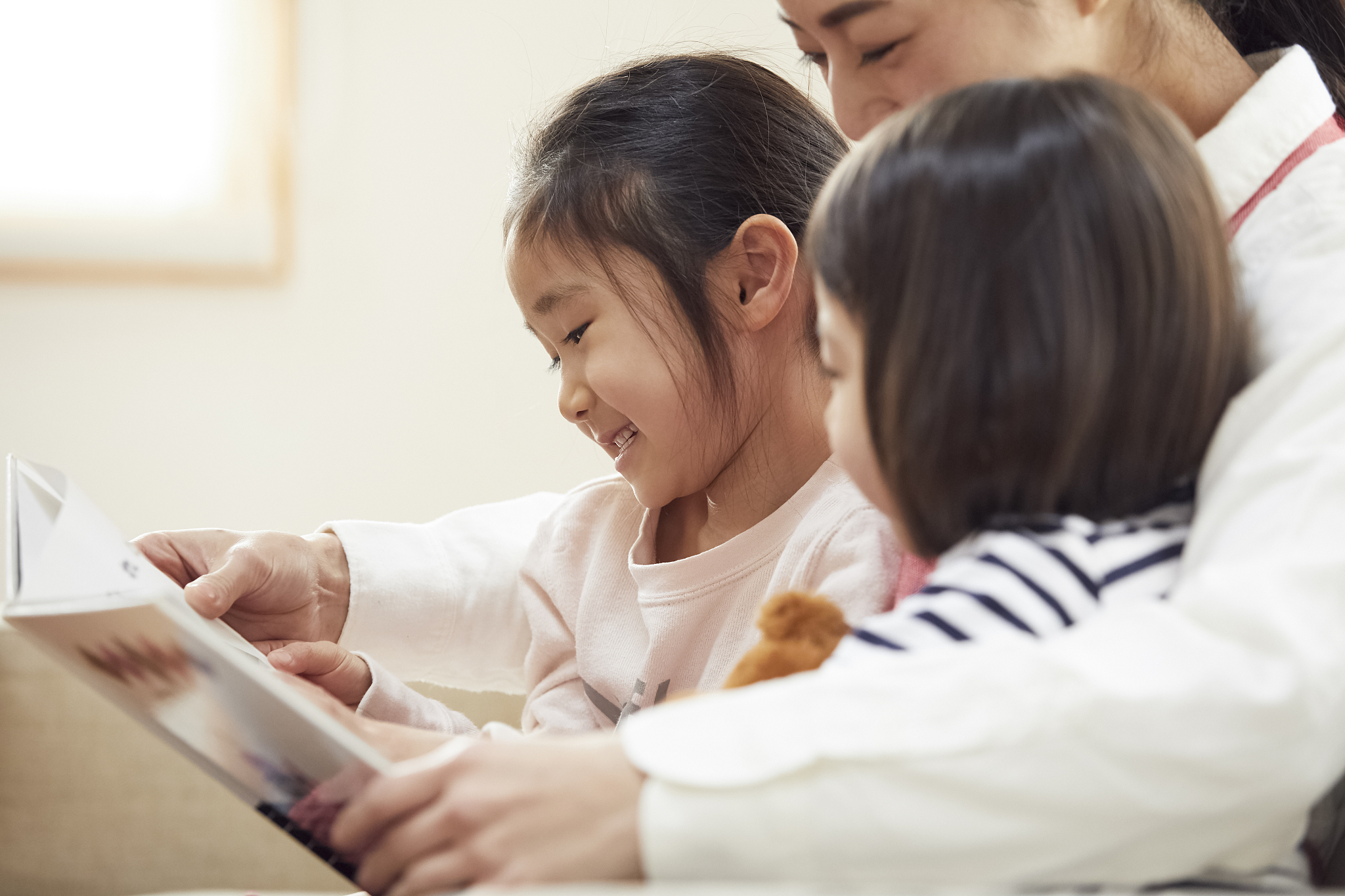 children having a teacher read and listen on the couch