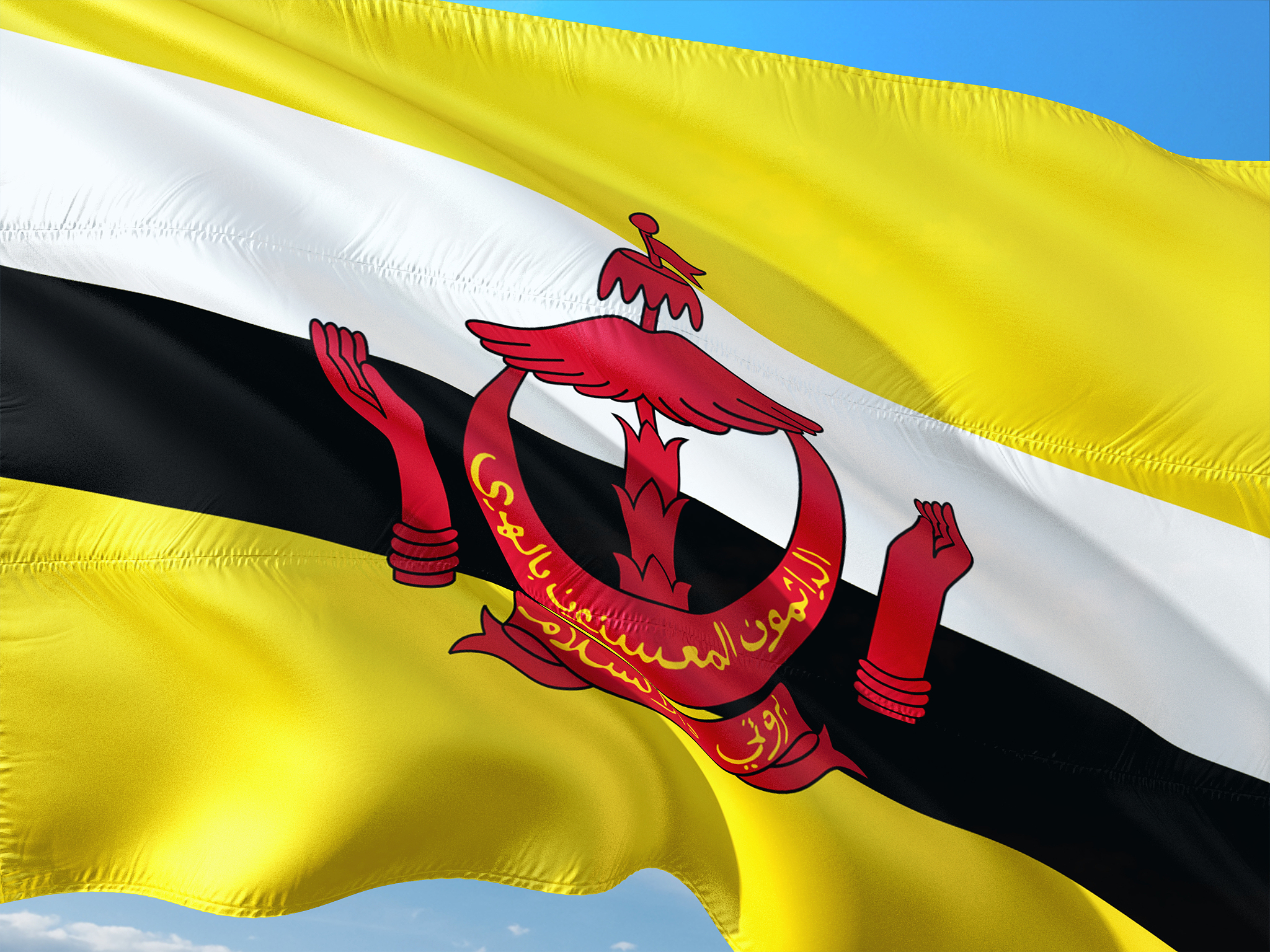 flag of brunei waving in the wind against deep blue sky. high qu