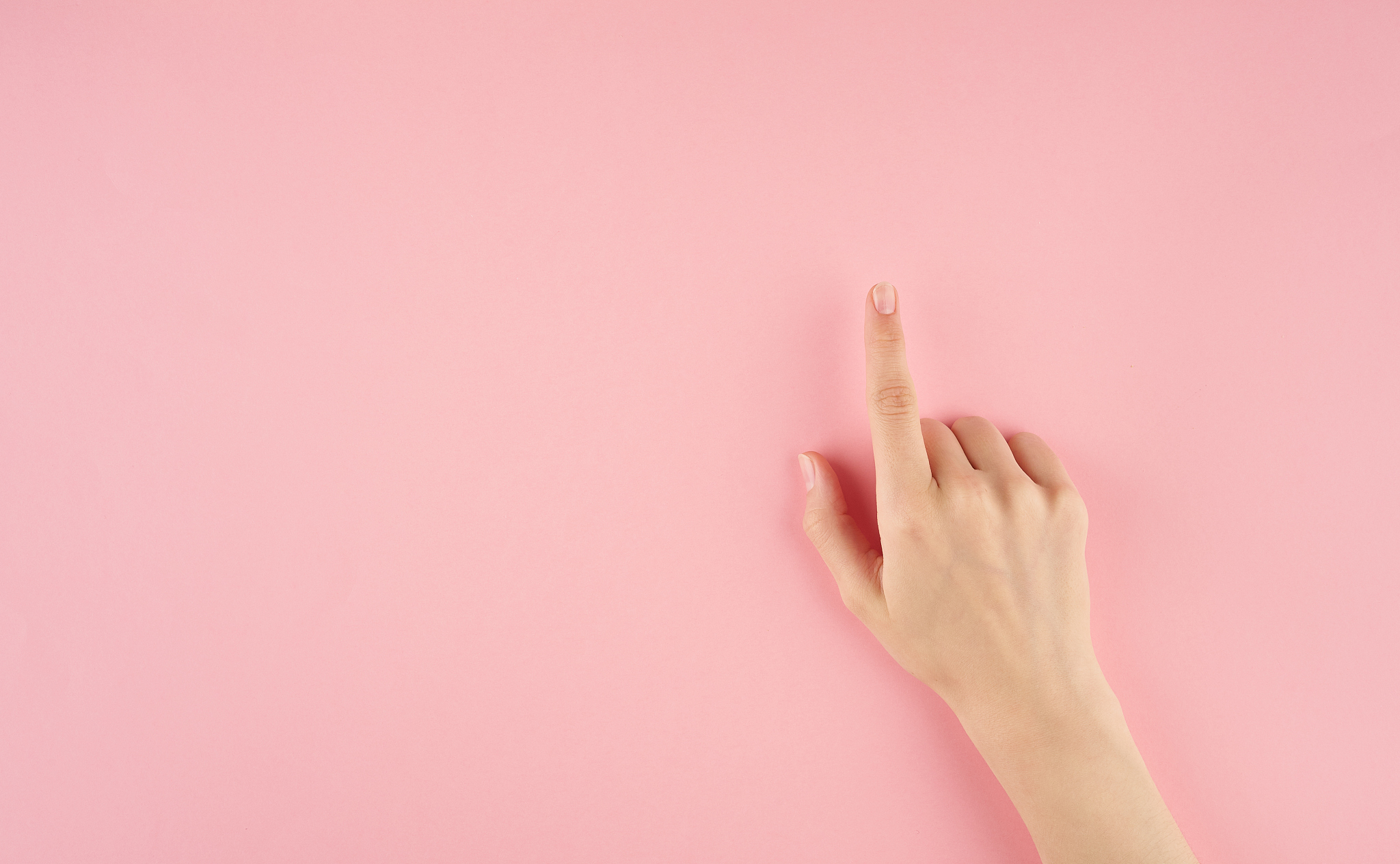 close-up of hand gesturing on pink background