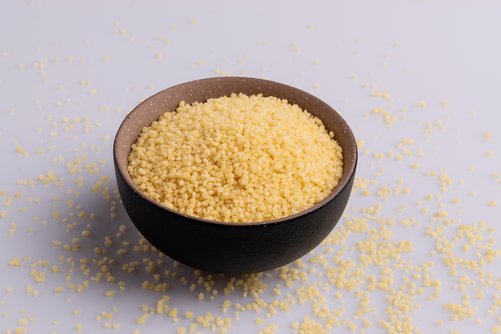 dry couscous isolated on white background, soft light, copy spac