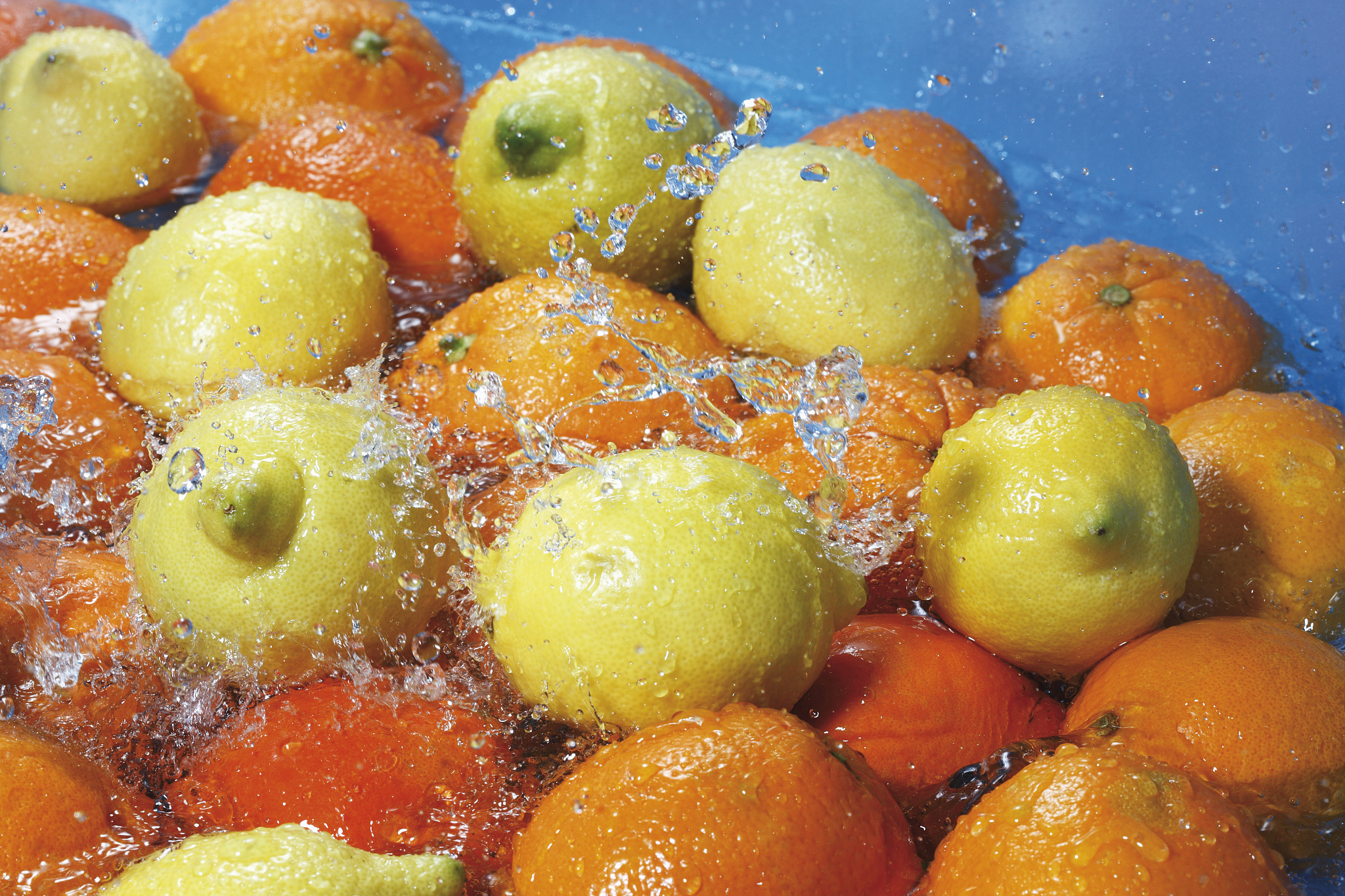 water splashing on fresh oranges and lemons