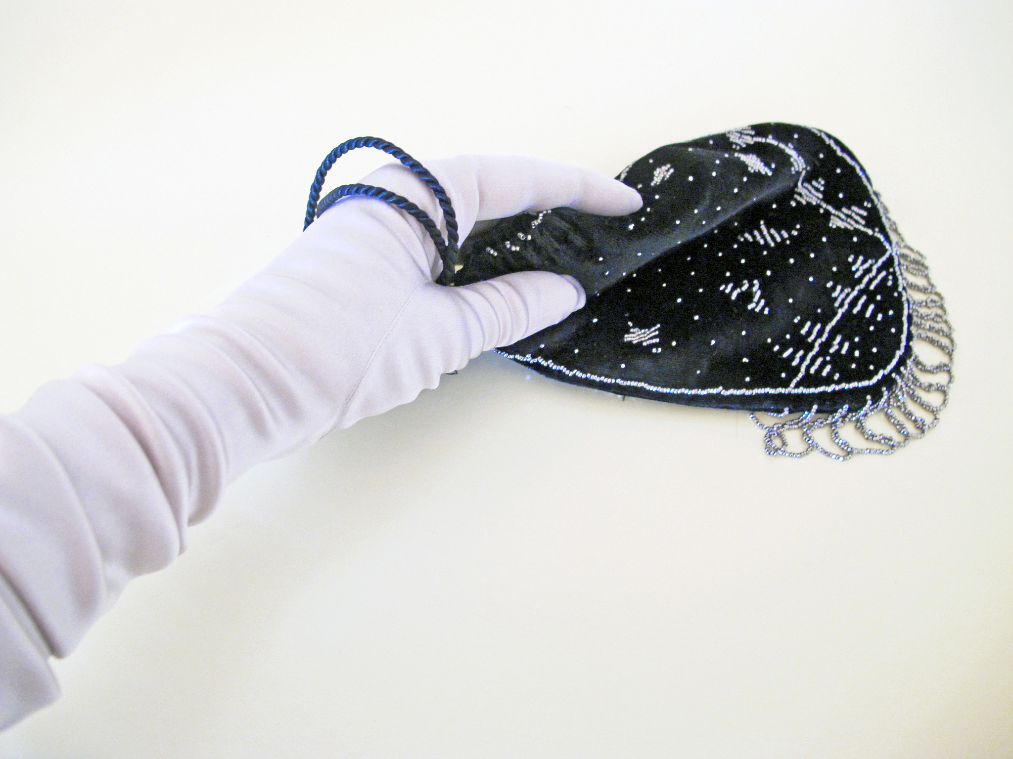 gloved hand holding purse