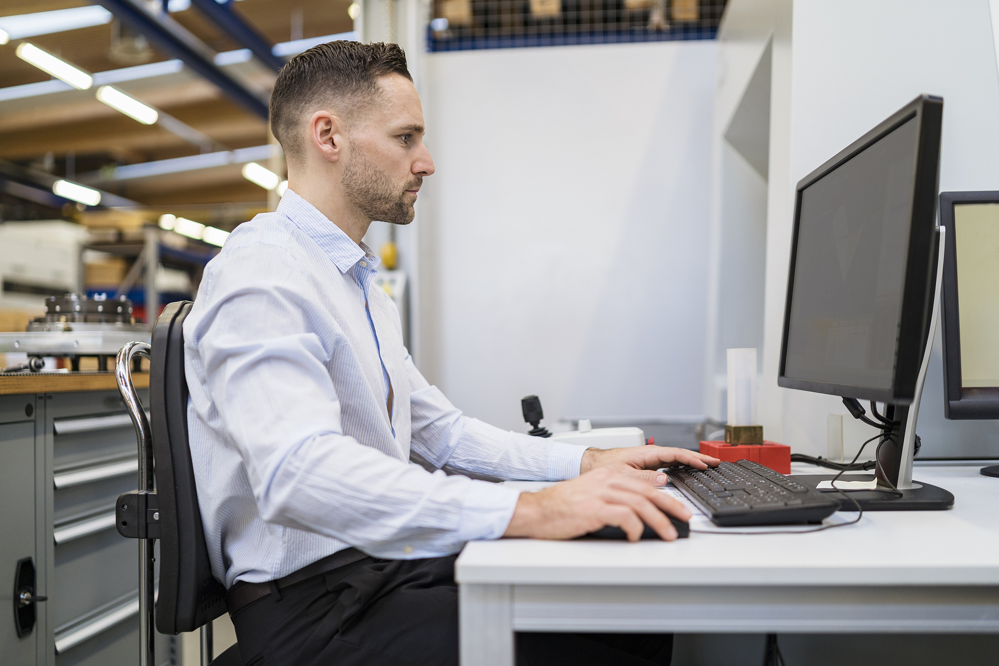 businessman using computer at desk in a factory