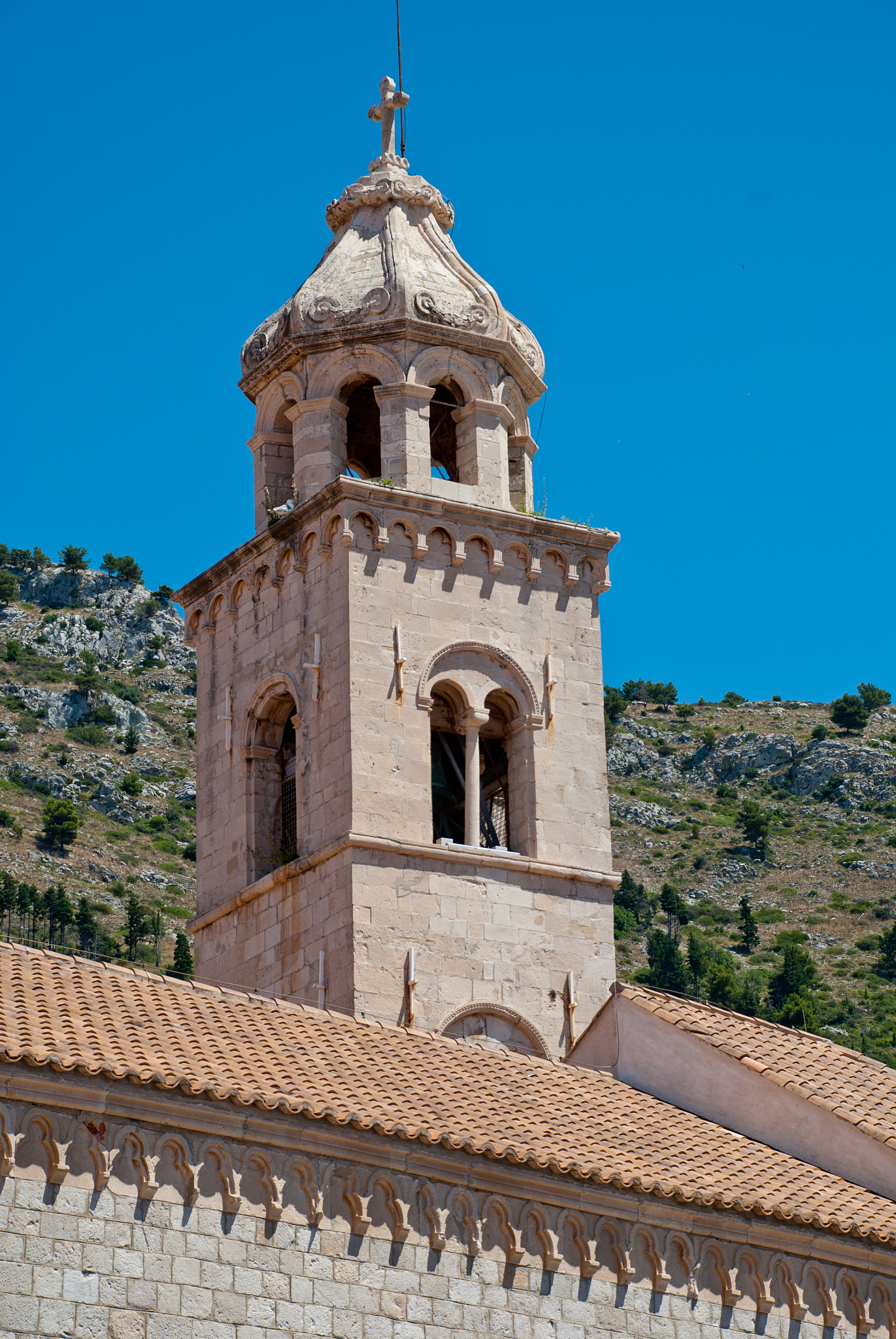 view of dominican monastery in dubrovnik with slim tower inside 