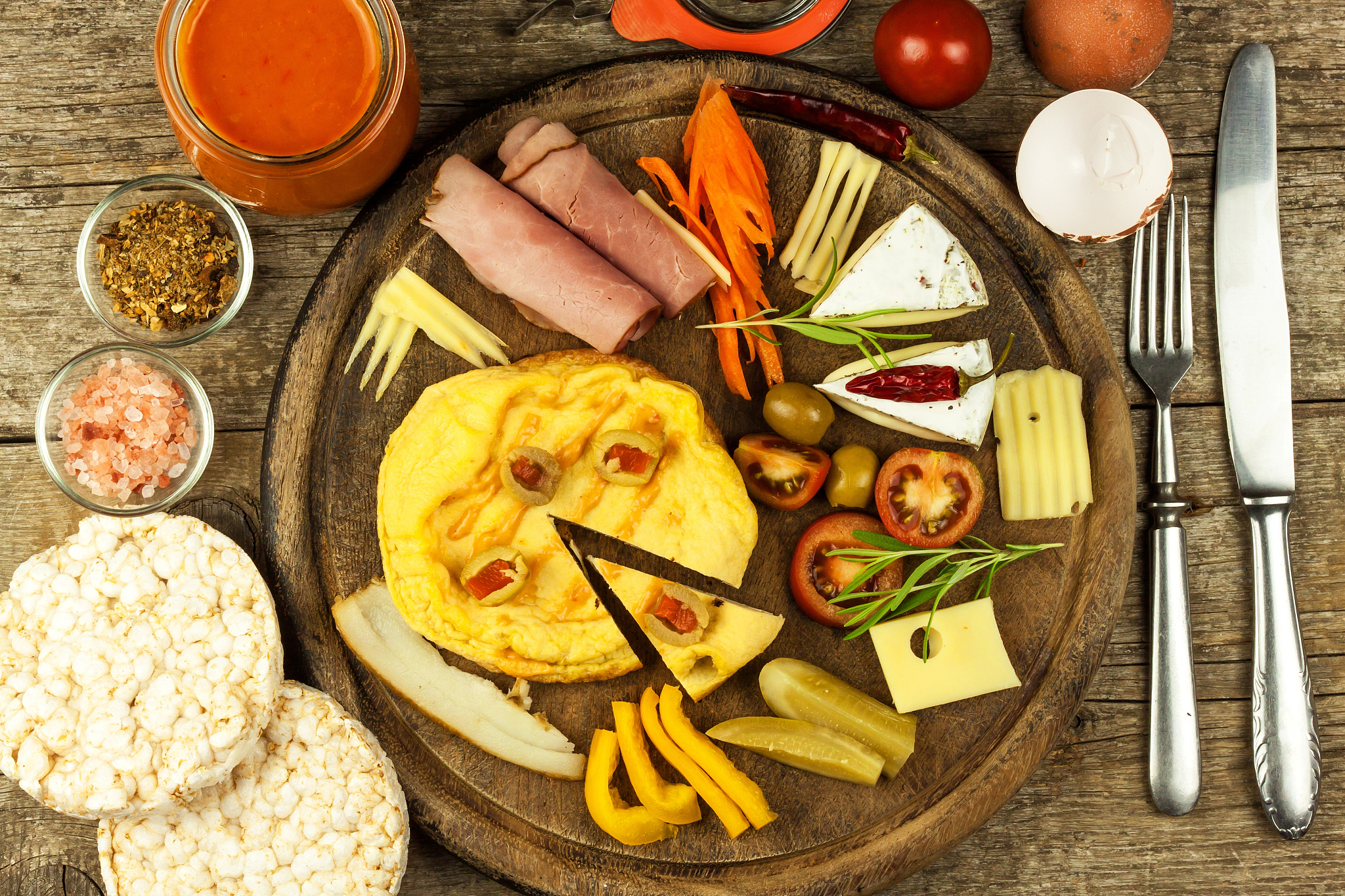 small egg omelet on the kitchen board. vegetables and spices.